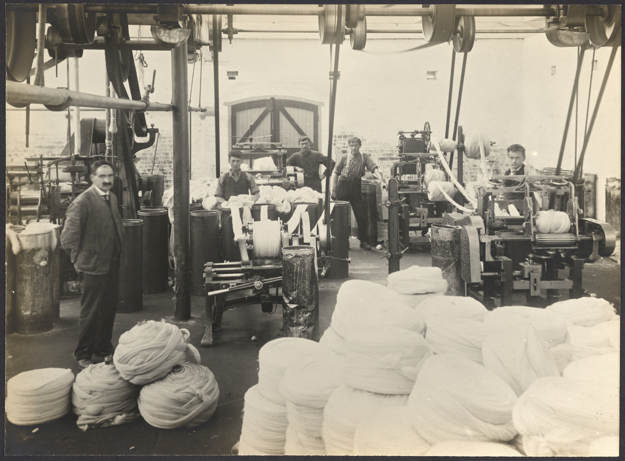 Workers with machines winding sliver or roving into large balls or 'bumps'