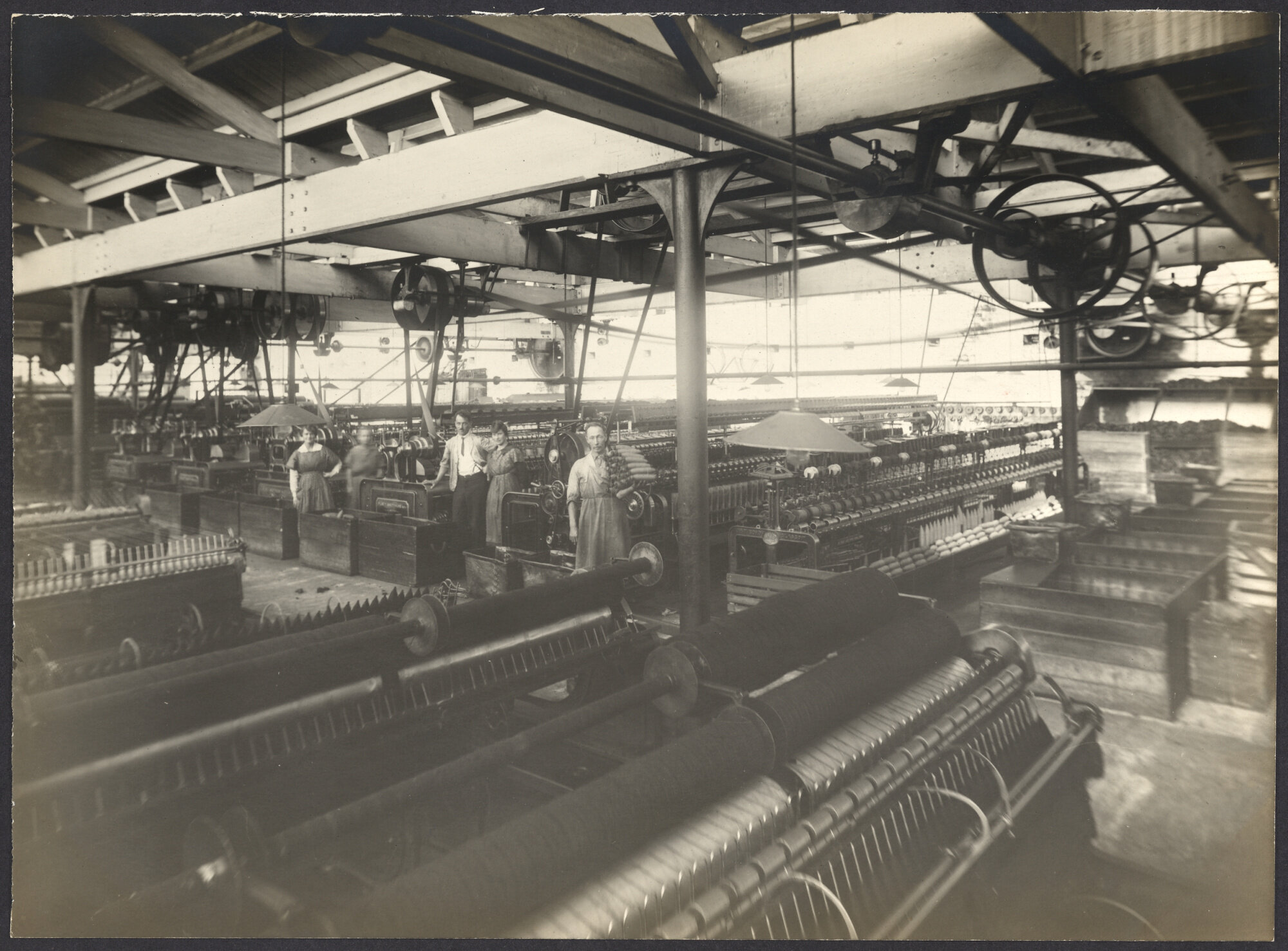 Workers with machines, winding yarn onto cones or pirns for either weaving or knitting