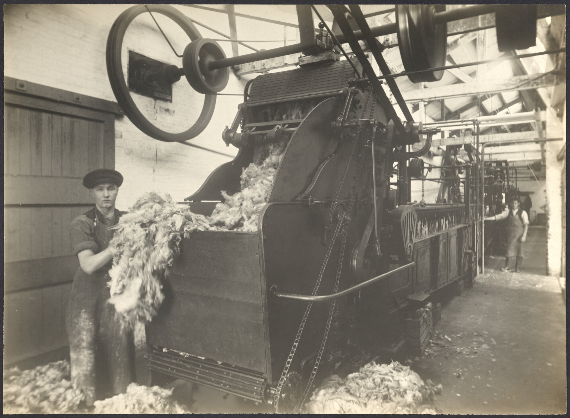 Two workers with wool scouring machine (?)