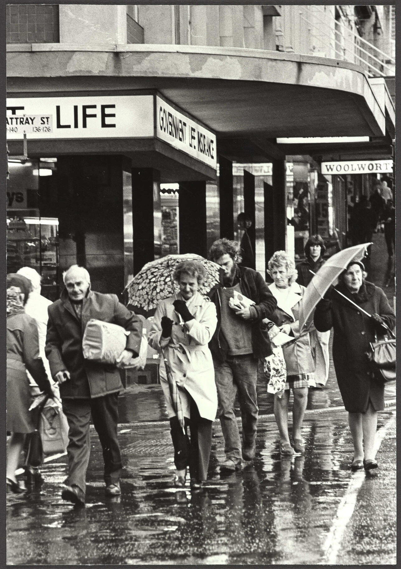 Pedestrians in wet weather crossing Rattray Street