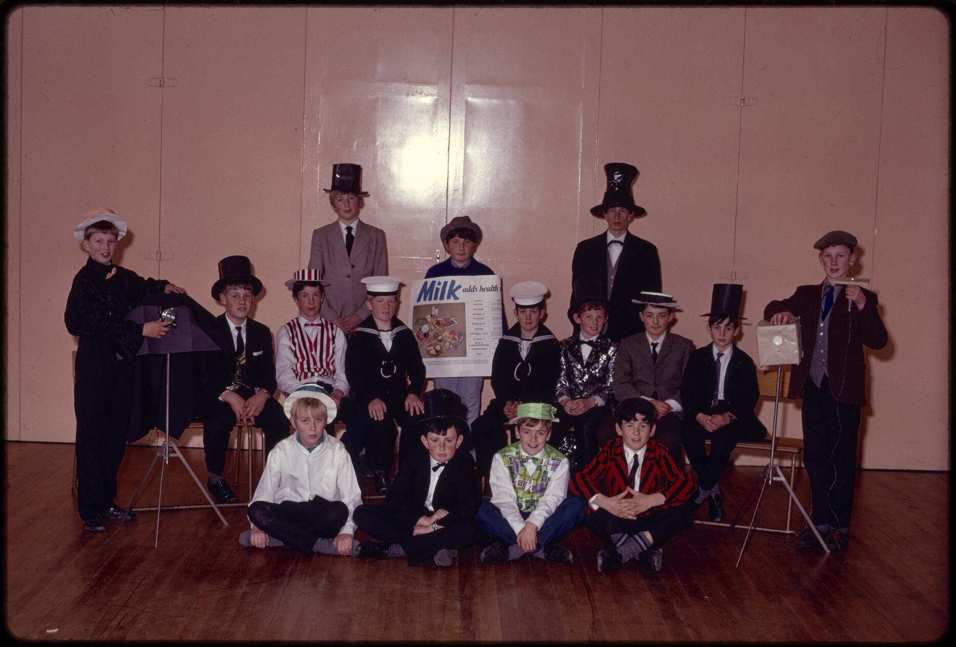 Boys in costume with 'Milk adds health' poster
