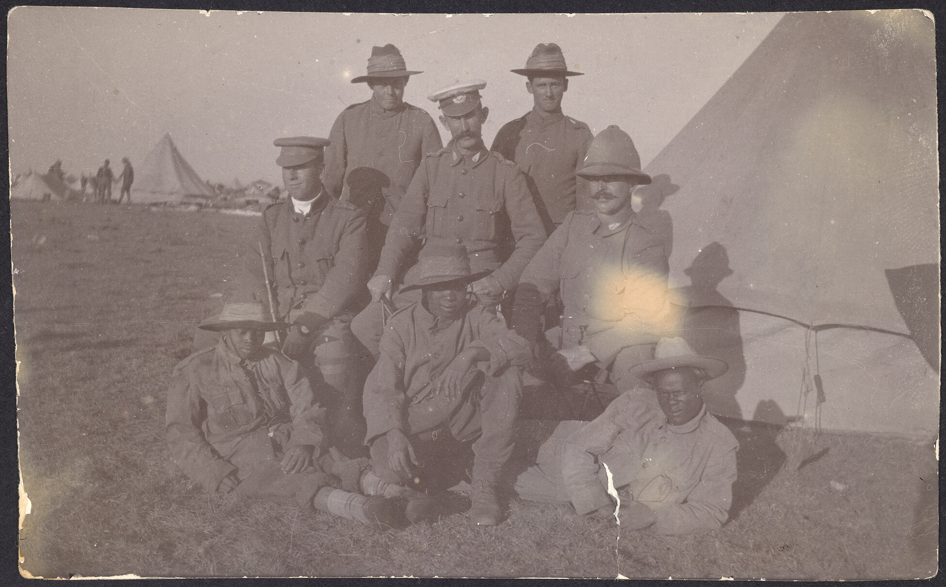 Eight soldiers outside a tent