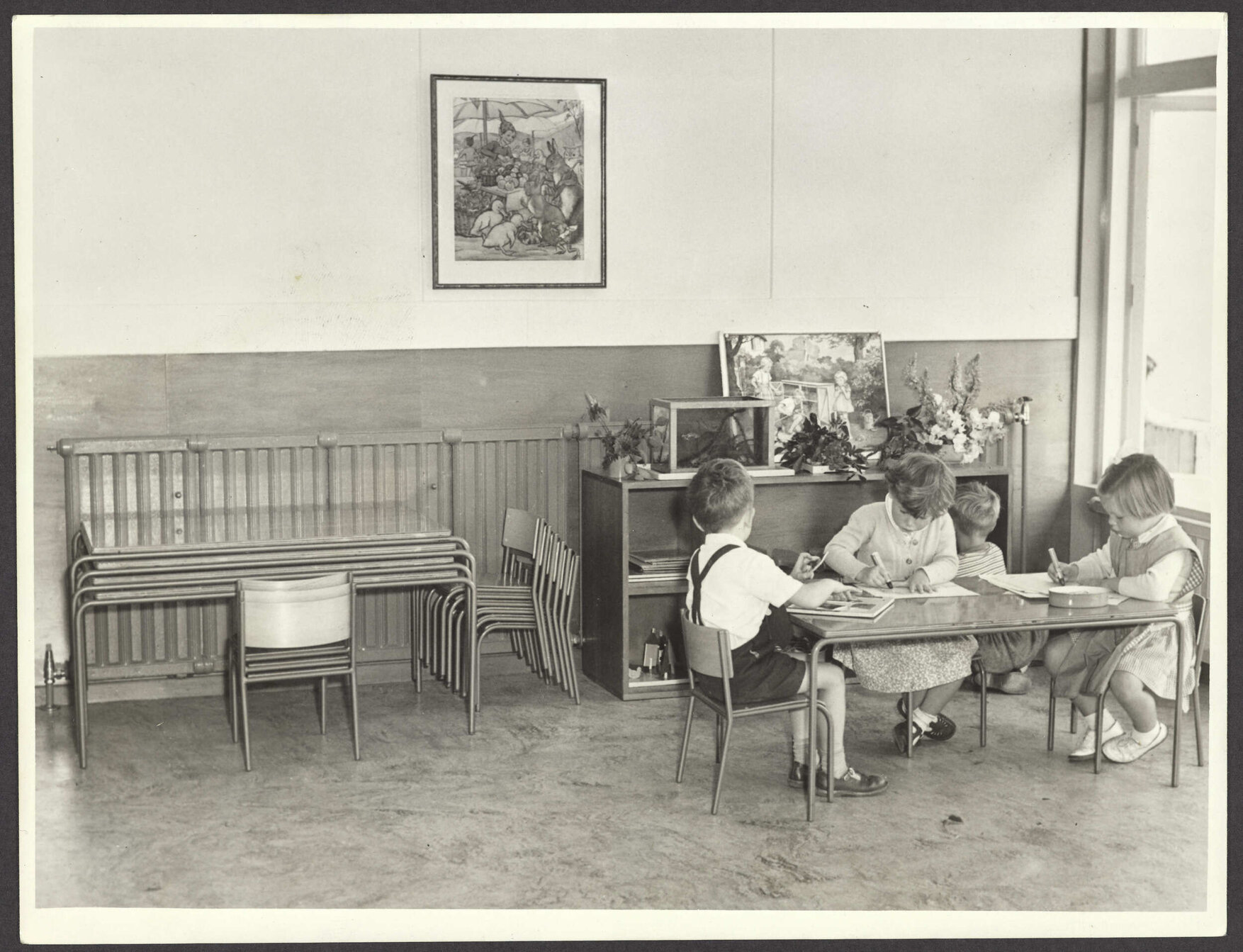 Preschool children in classroom with metal-framed chairs and tables