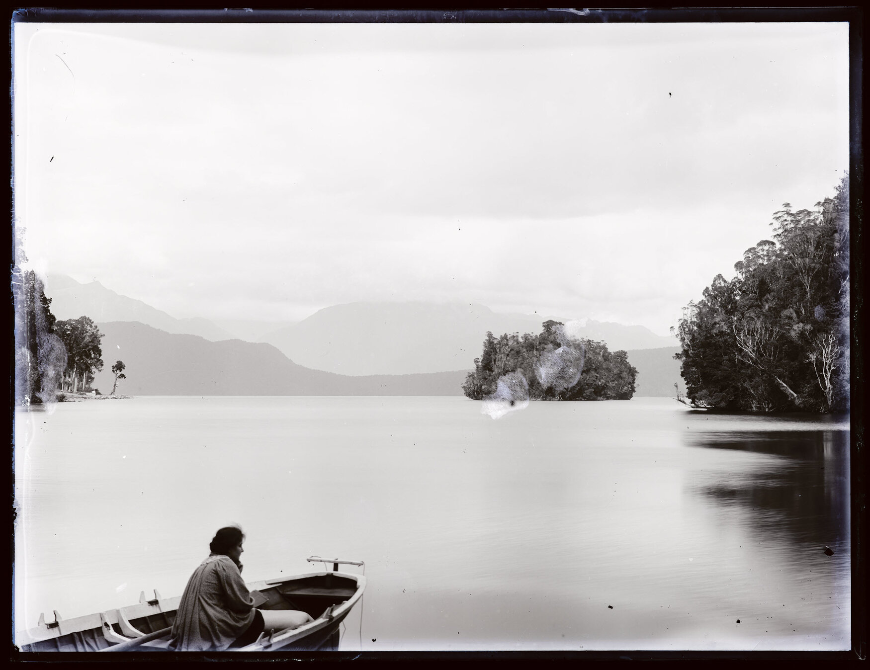 Person in a boat on a large body of water, small island in distance, Westland