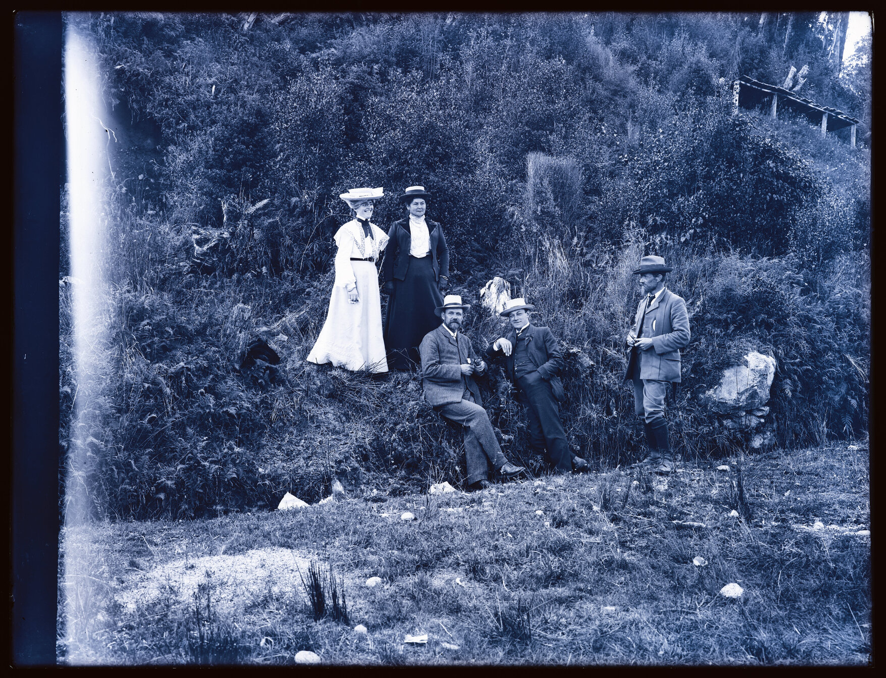 Group of five people next to a steep bank
