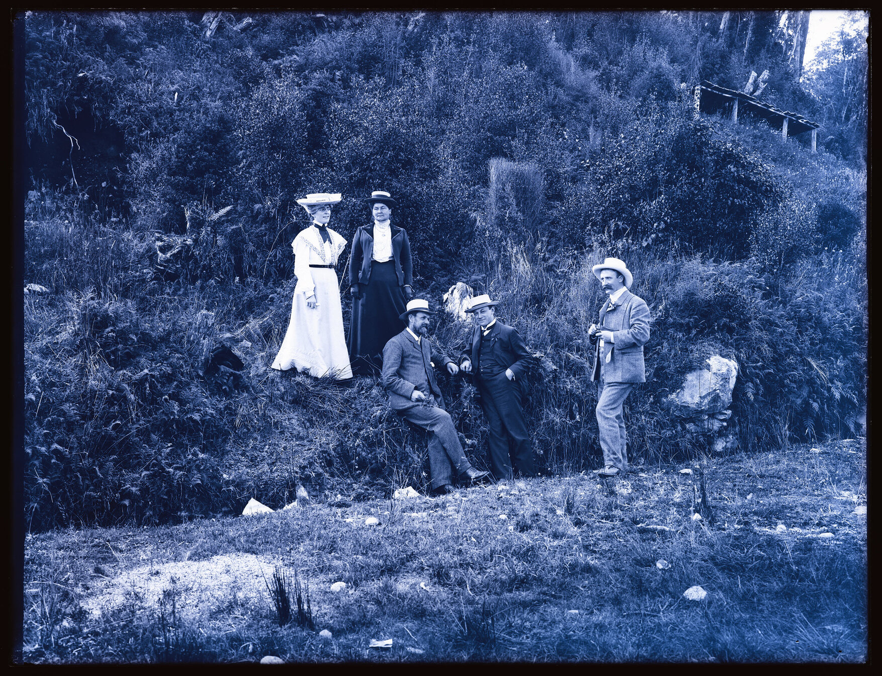 Group of five people next to a steep bank