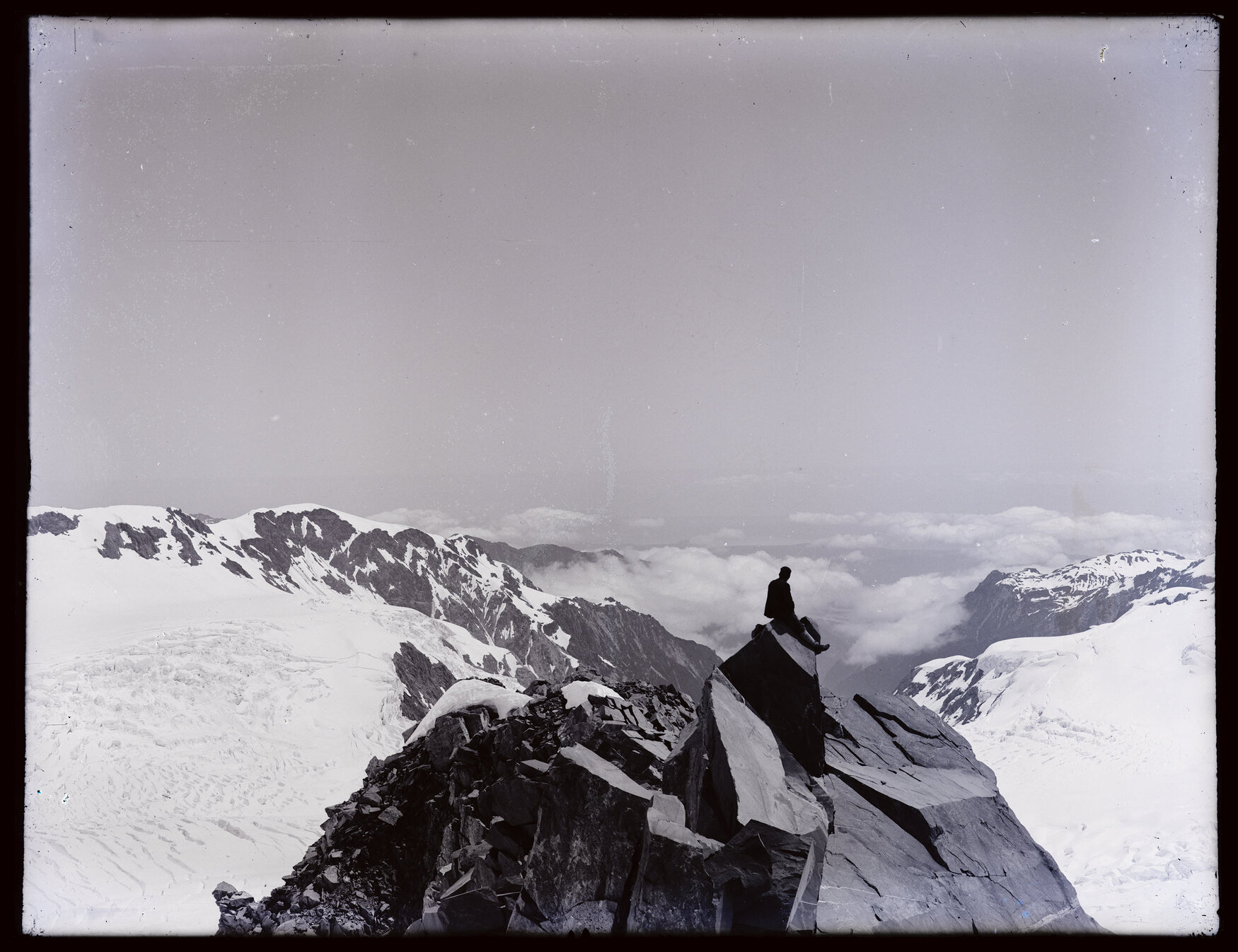 Person seated on rock, looking west, upper Fox Glacier / Te Moeka o Tuawe