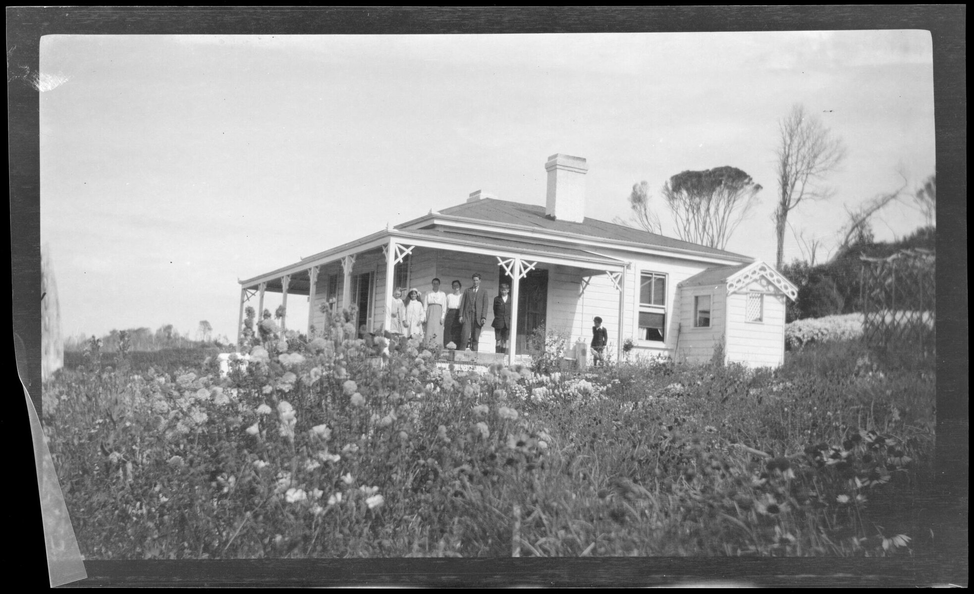Family standing in porch of farm house