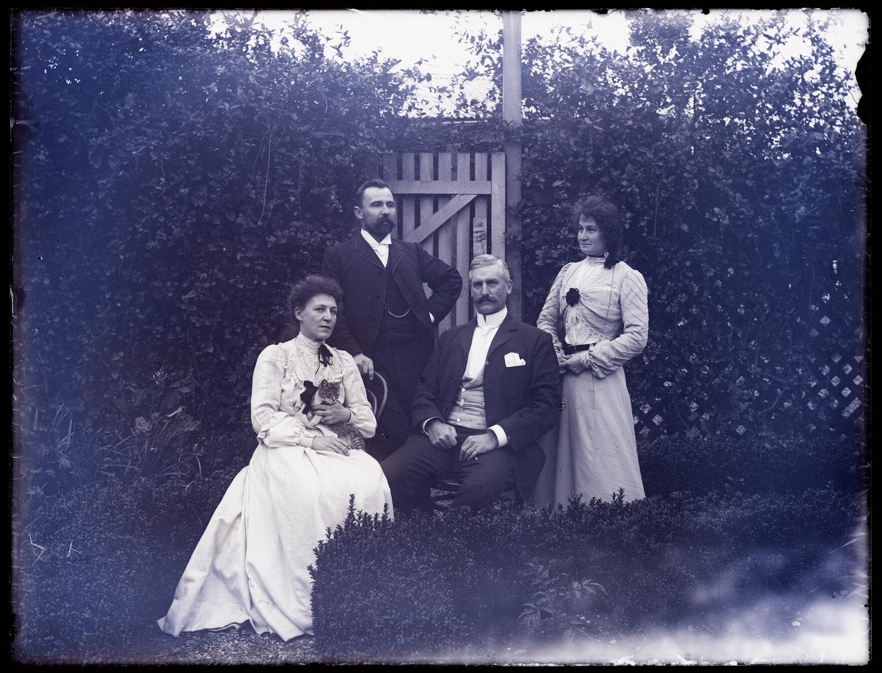 Four people in a garden, Teichelmann second from left