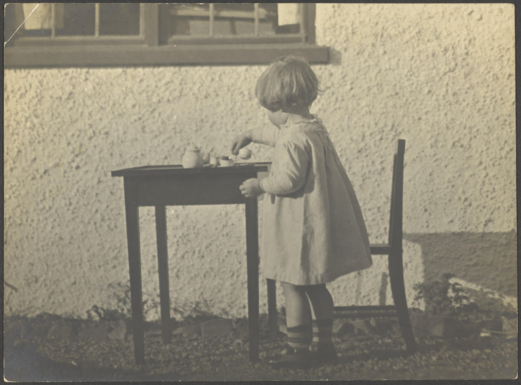 Young girl playing with a toy tea set
