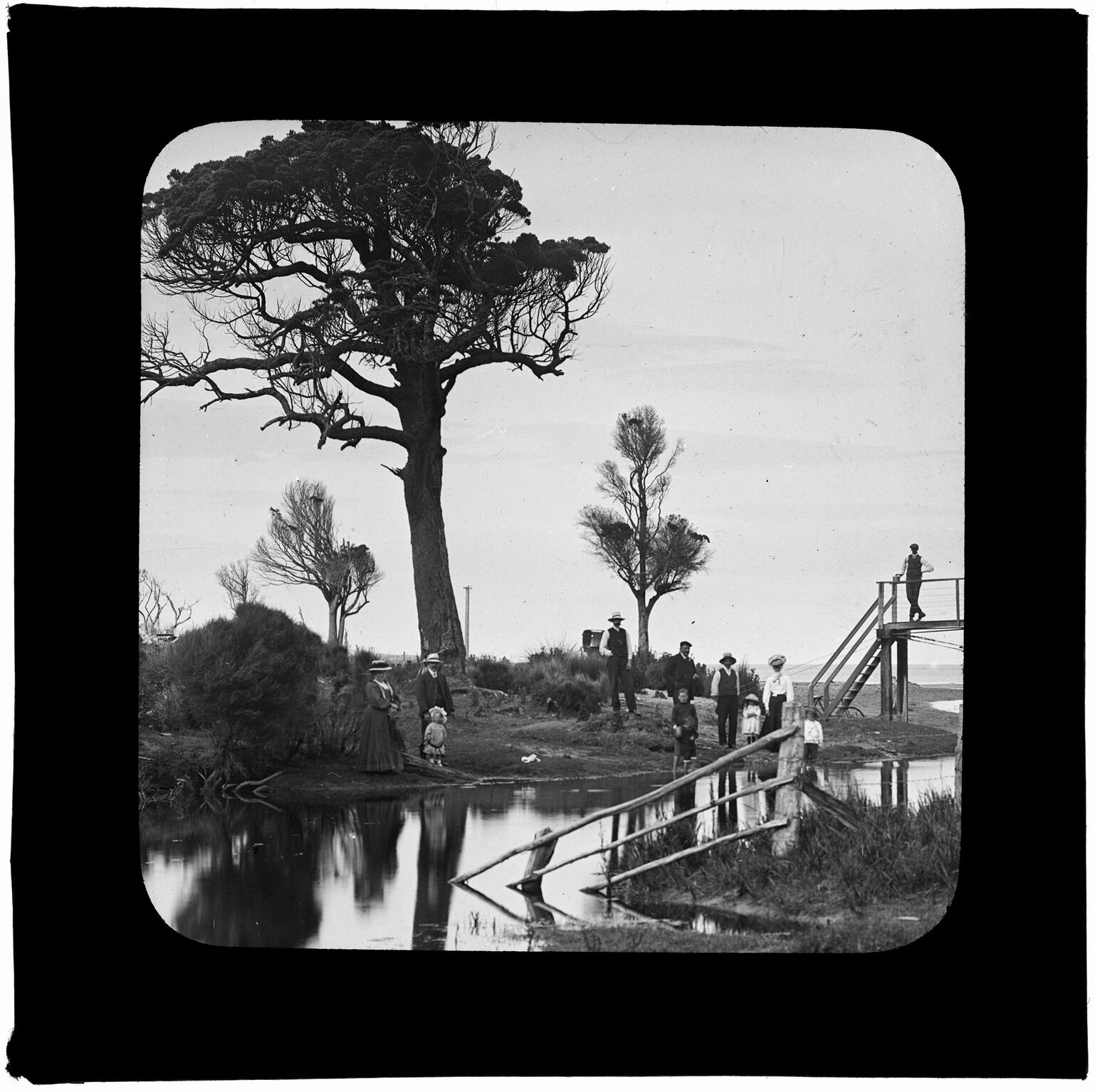Group of people beside waterway leading to ocean
