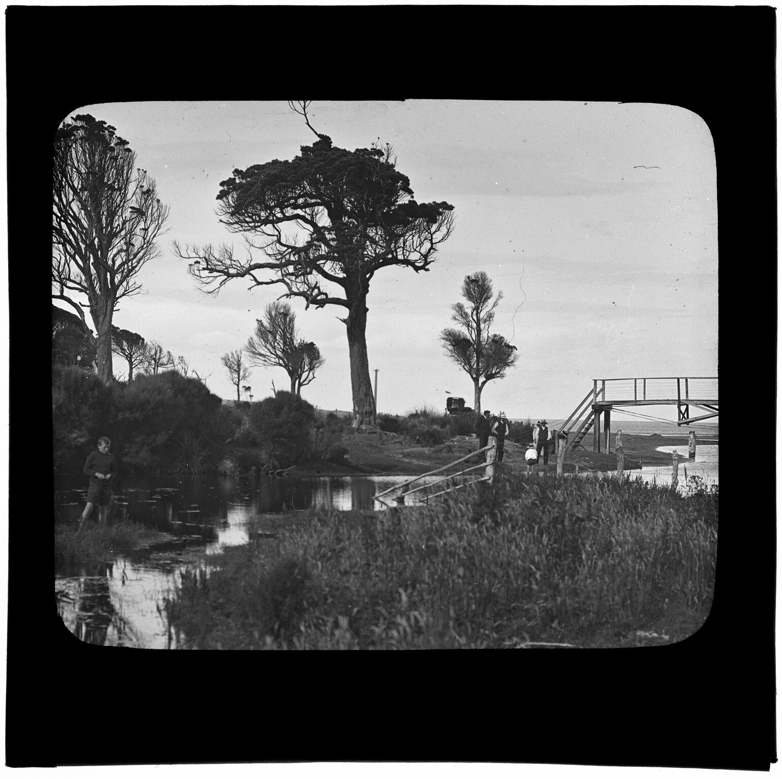 Group of people beside waterway leading to ocean