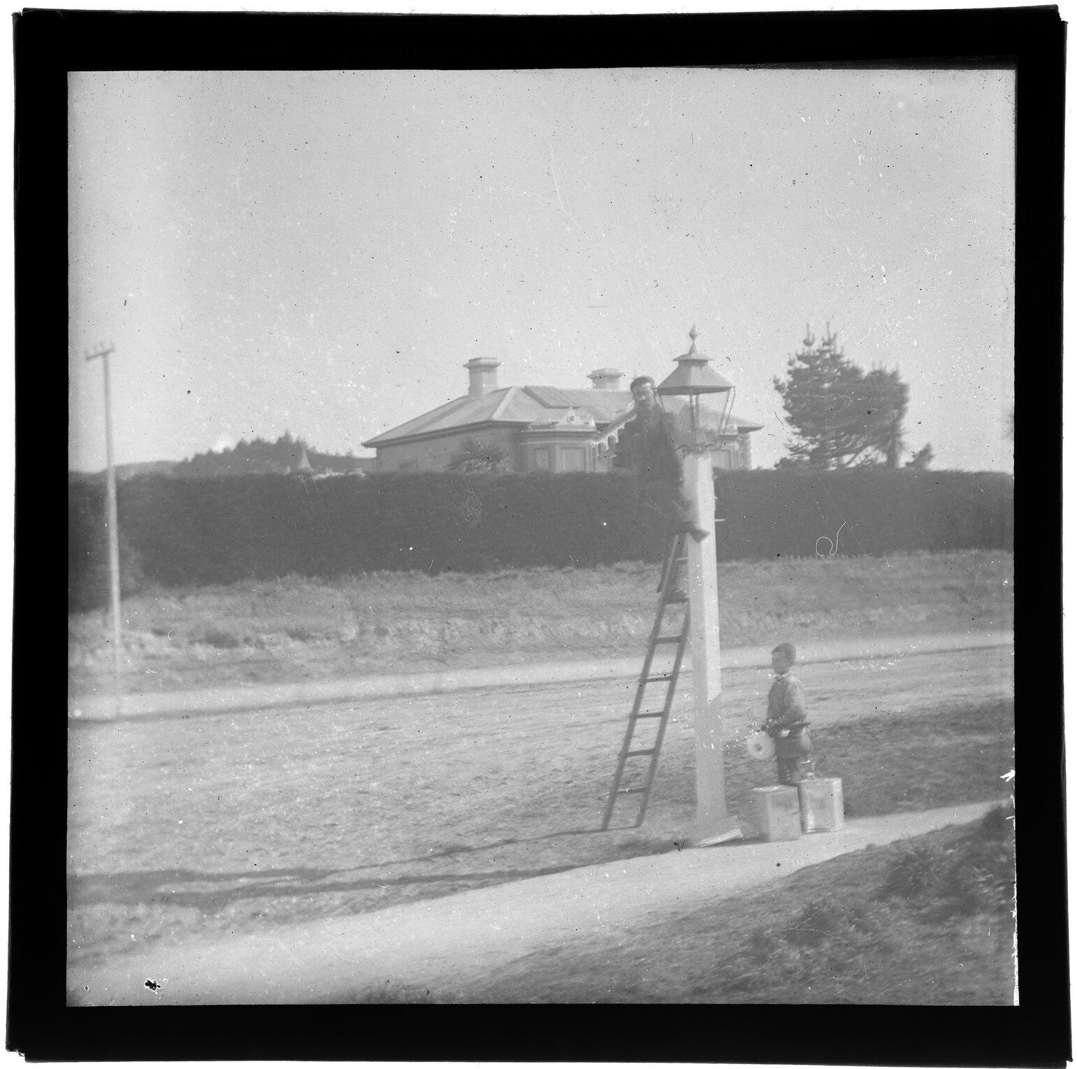 Man and boy attending to a street lamp
