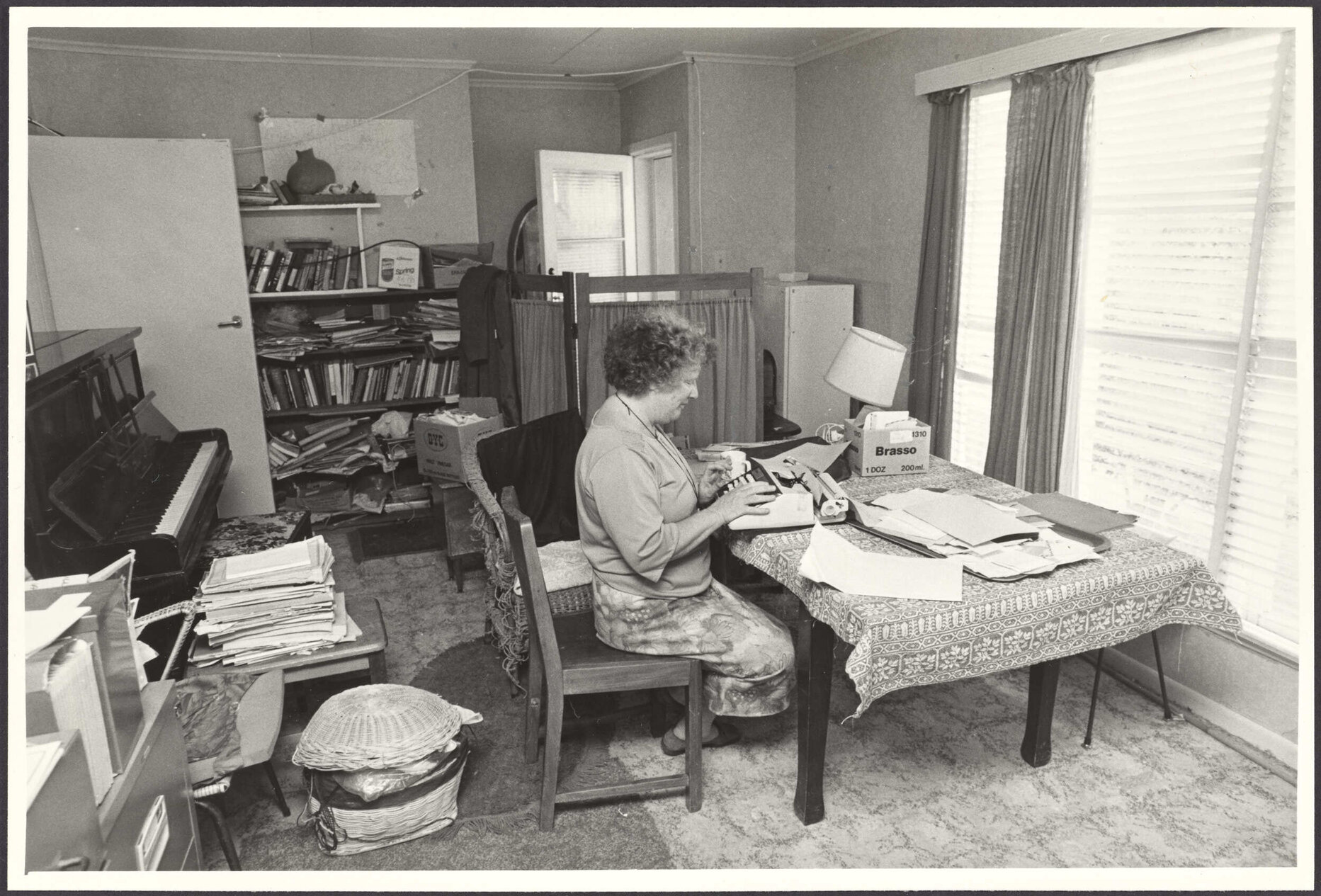 Janet Frame typing in a room in her house