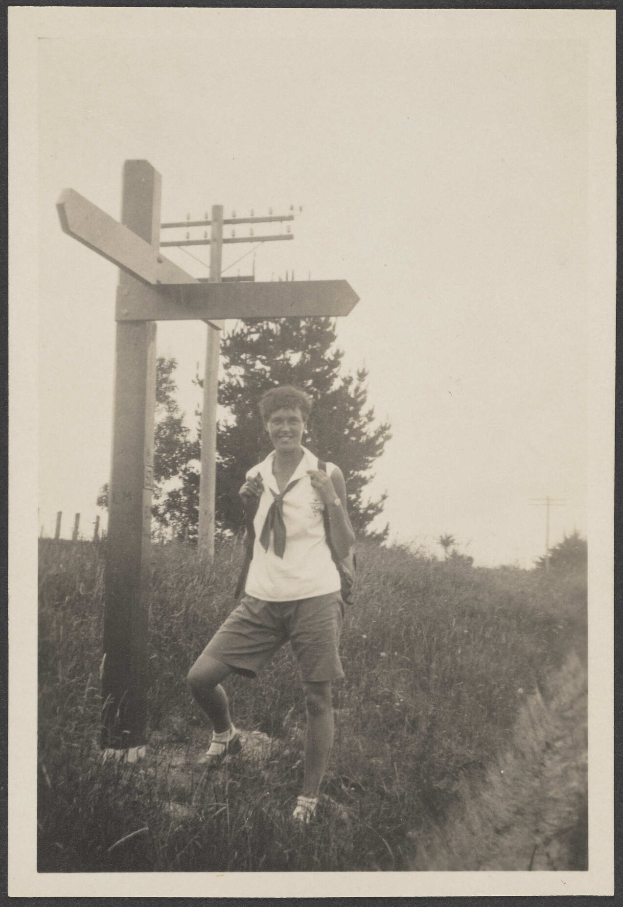 Unidentified woman under a street sign
