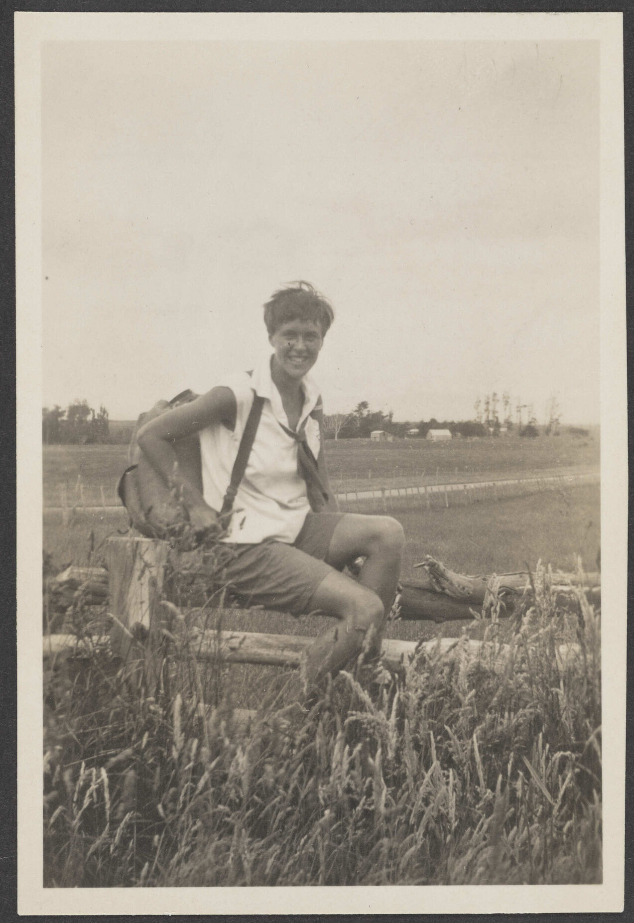 Unidentified woman sitting on a fence