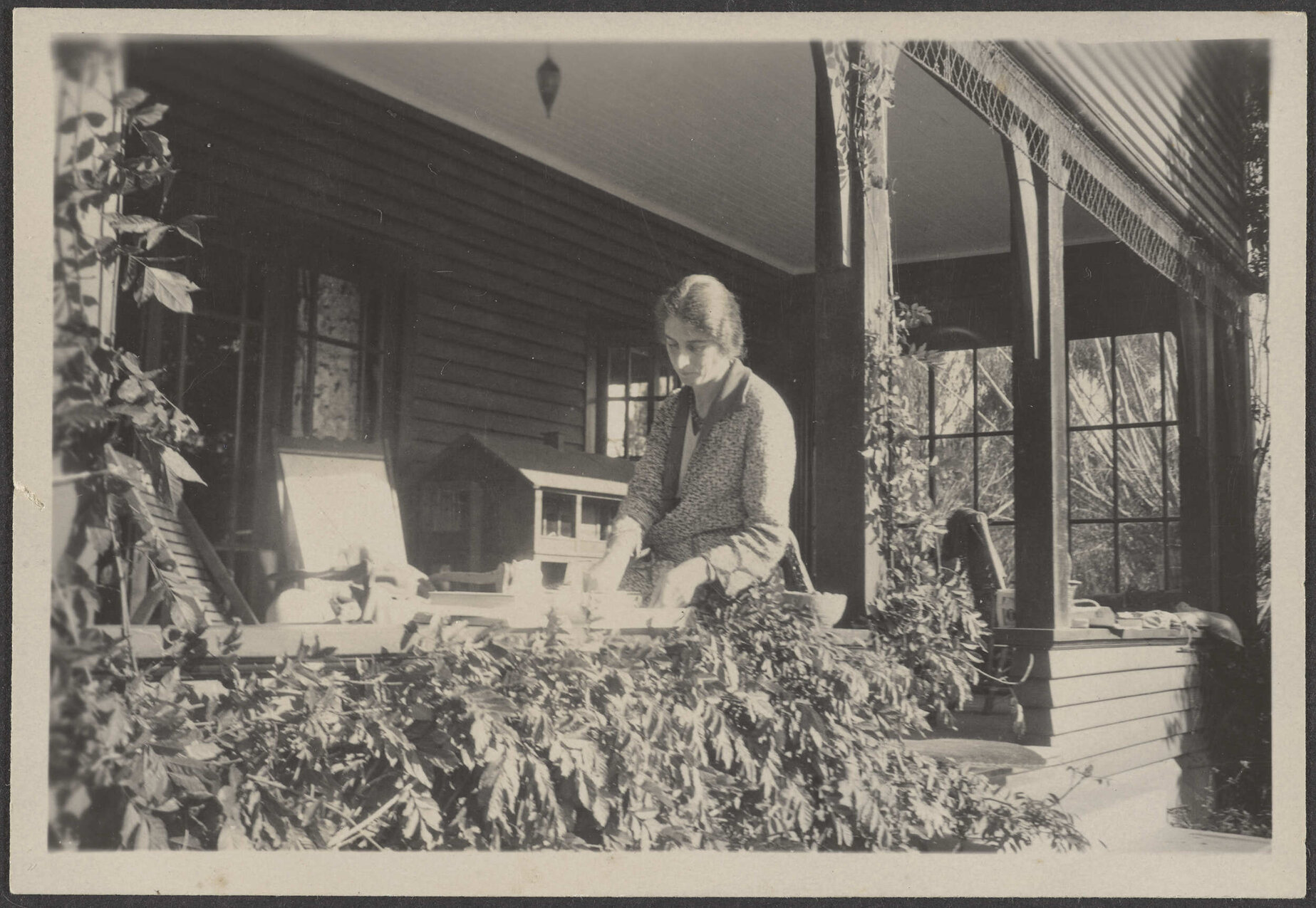 [Eunoe Stamers-Smith?] sitting on porch 