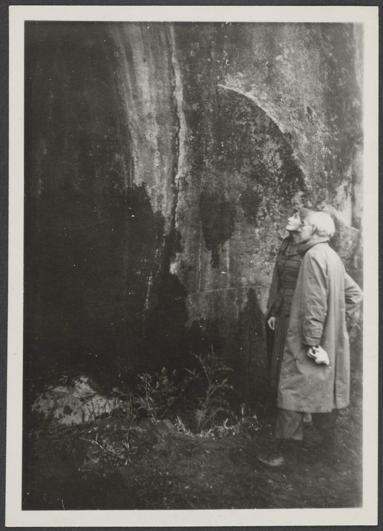 Two people studying a rock wall