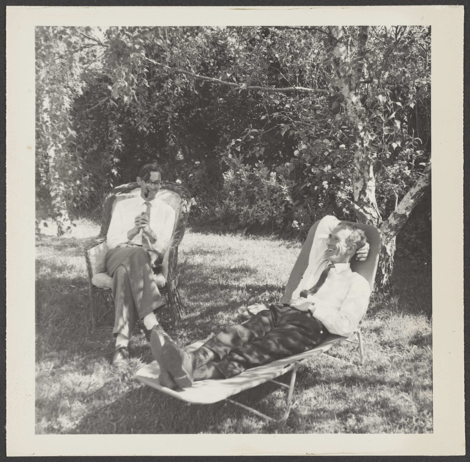 W.H. Oliver and Charles Brasch sitting under a tree