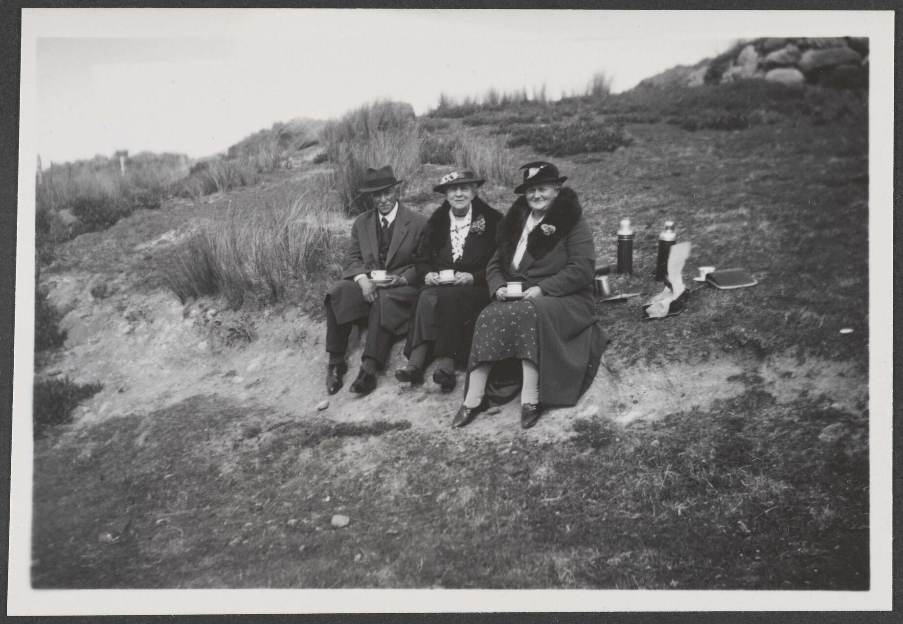 Three people sitting outside