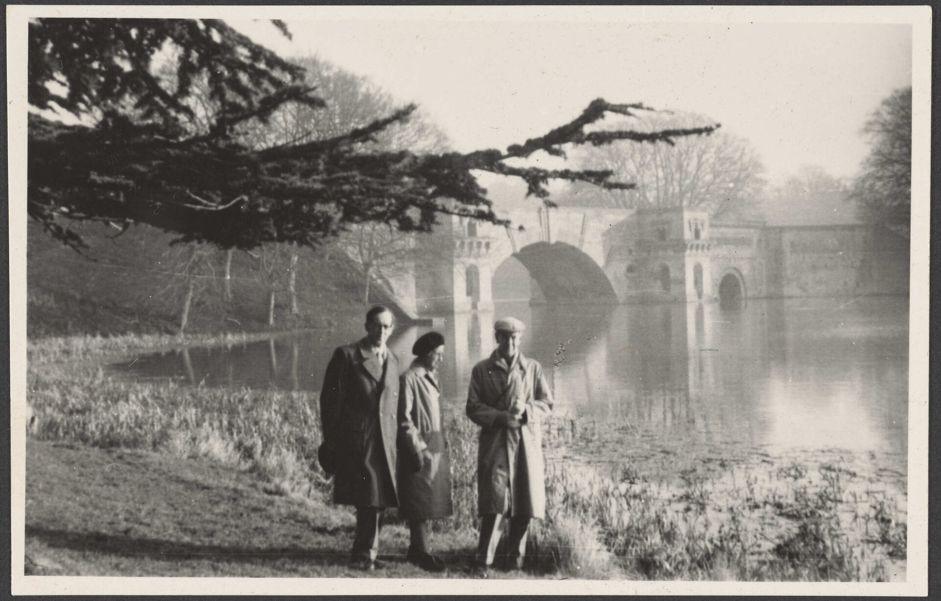 Three people walking lakeside at Blenheim Palace