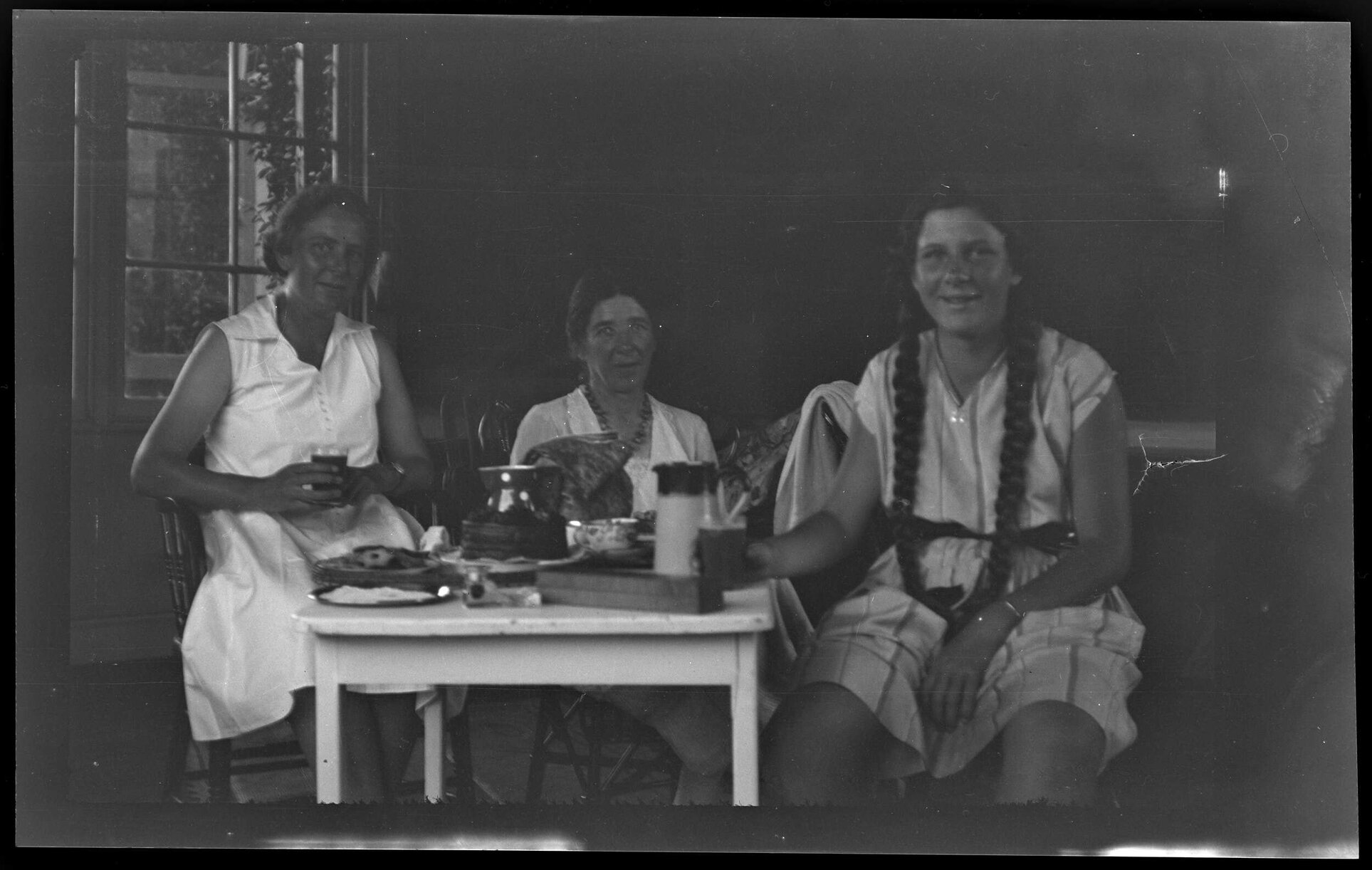 Three women with food and drink at a small table