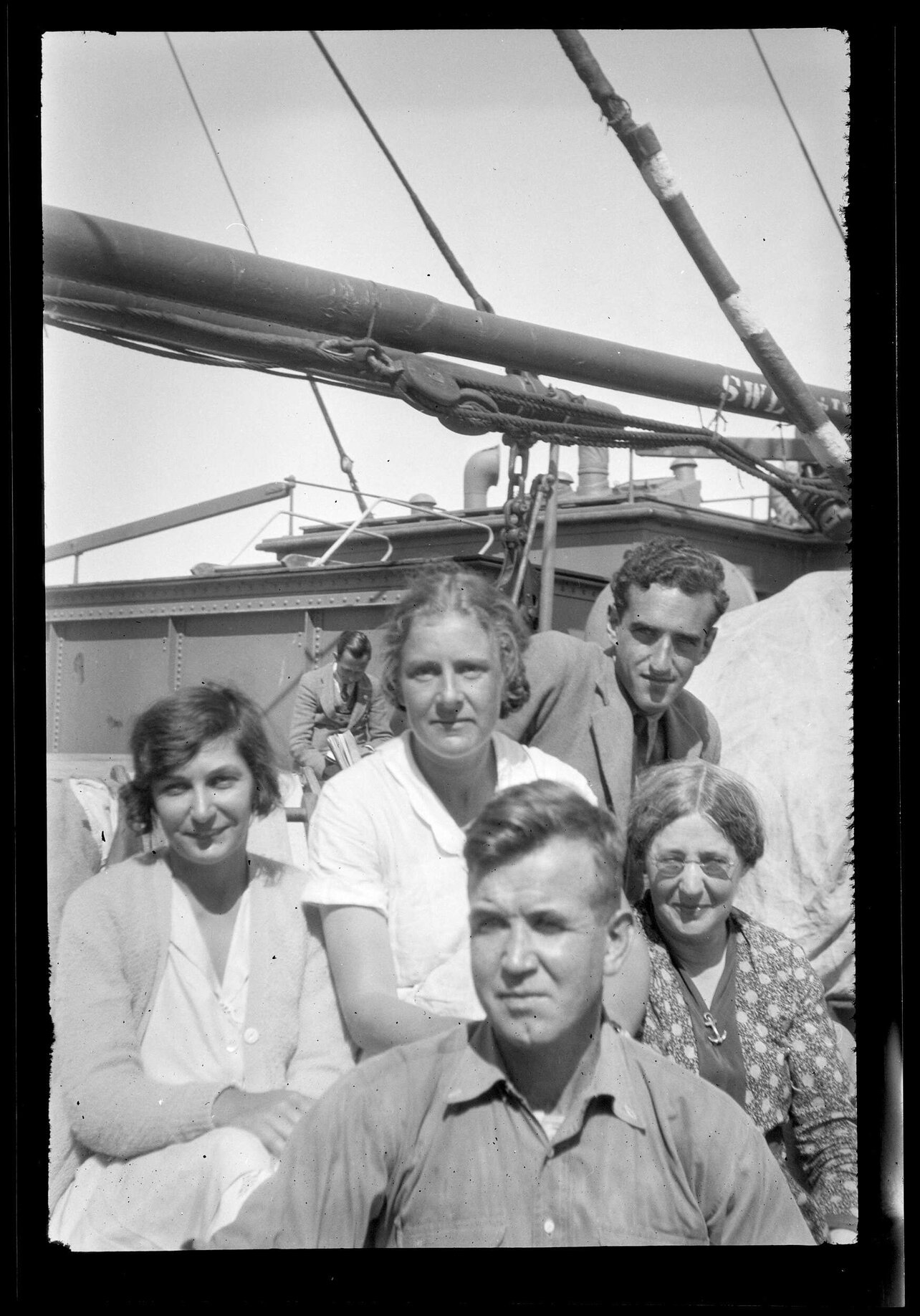 Charles Brasch in a group of five people, on the deck of a ship
