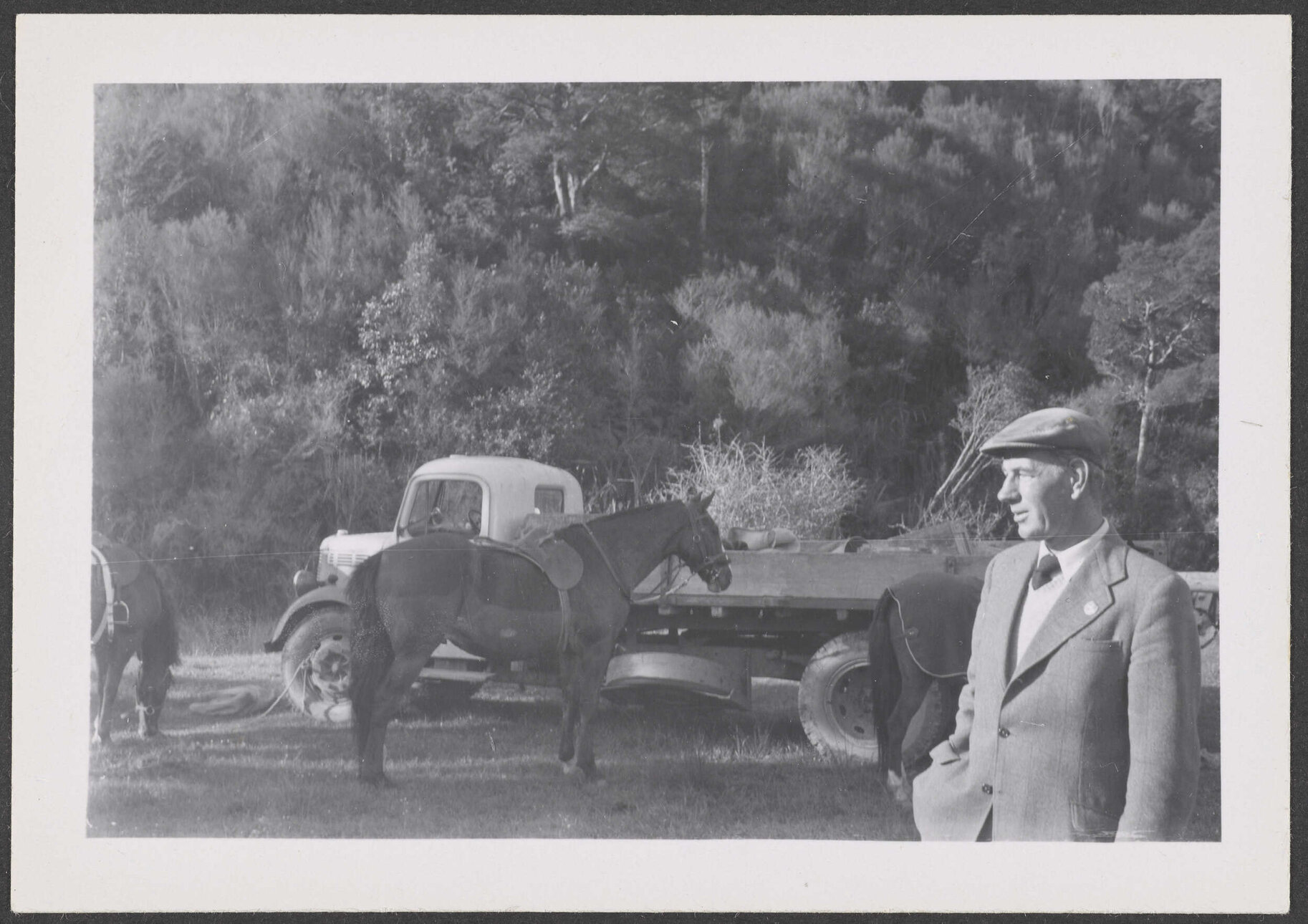 Man next to a truck and a horse