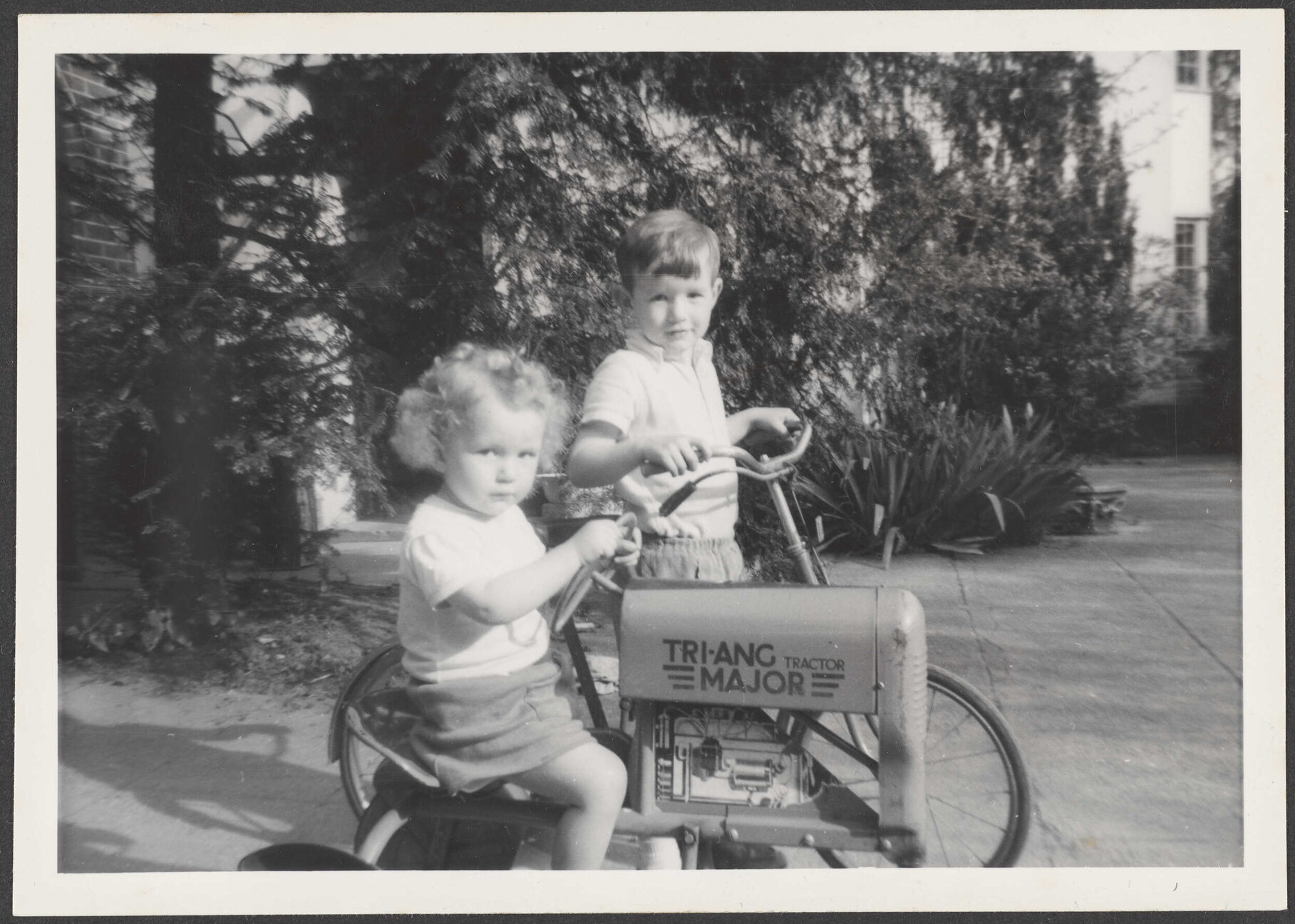 Two children with a toy tractor