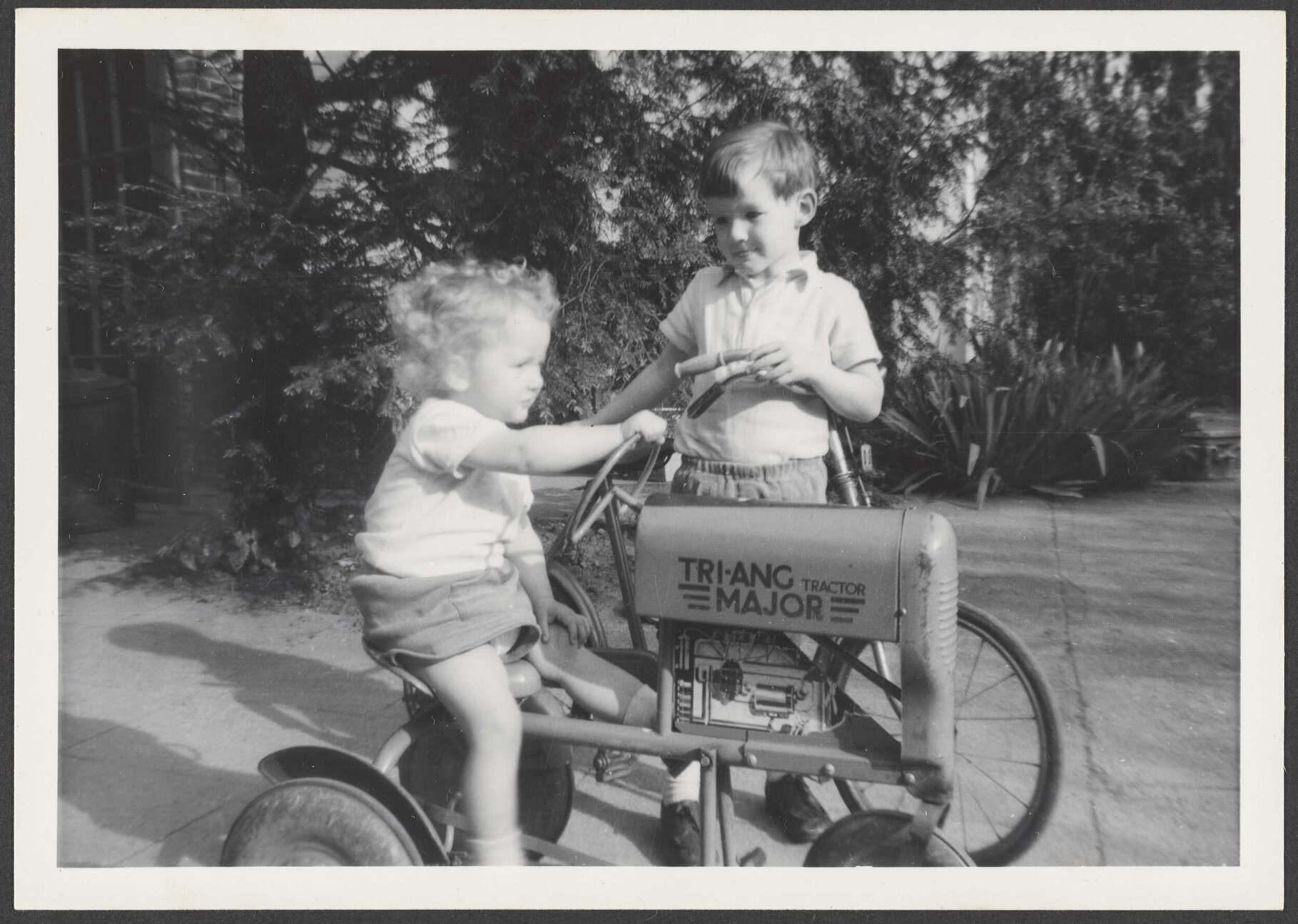 Two children with a toy tractor