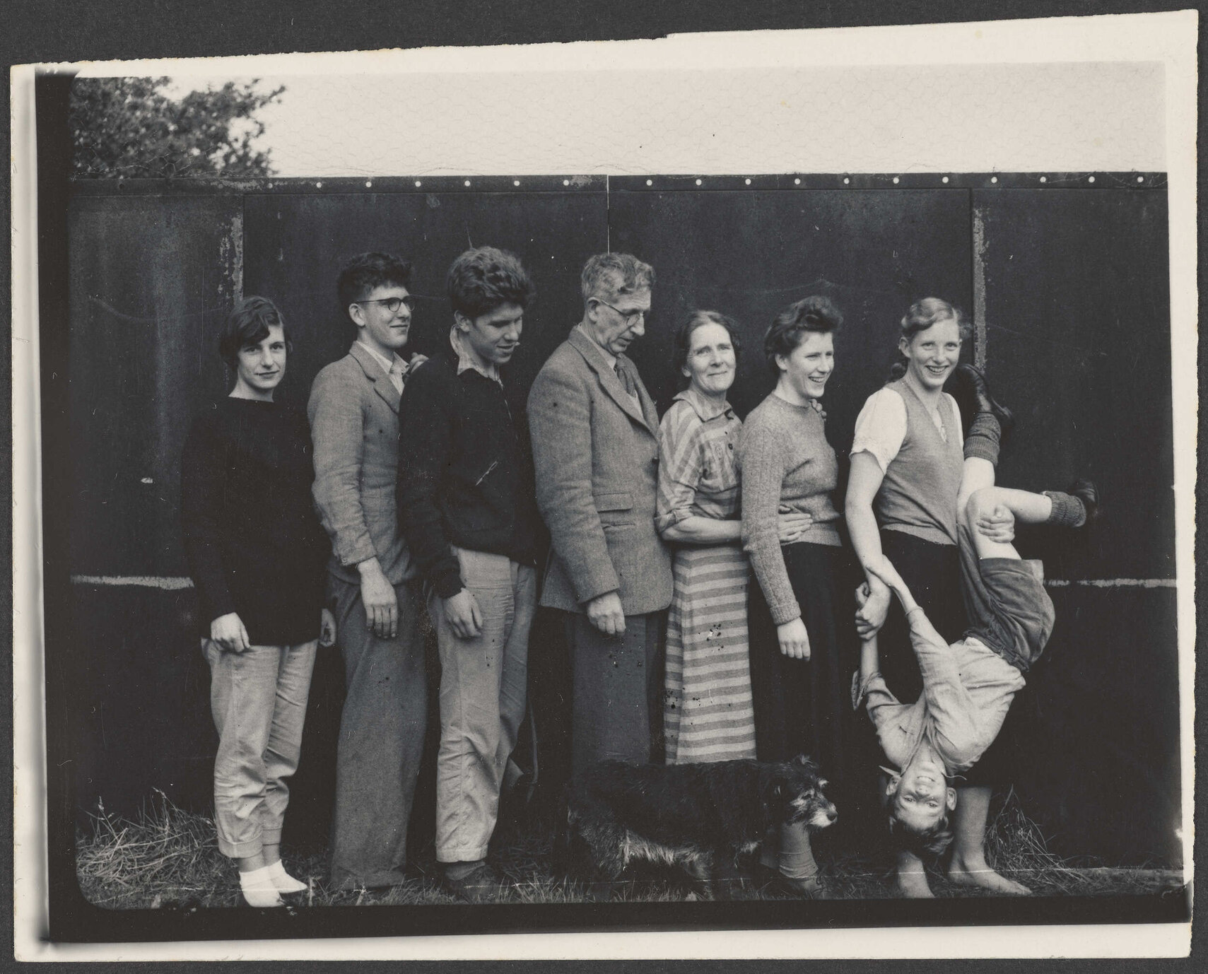 Family photograph of eight people and a dog
