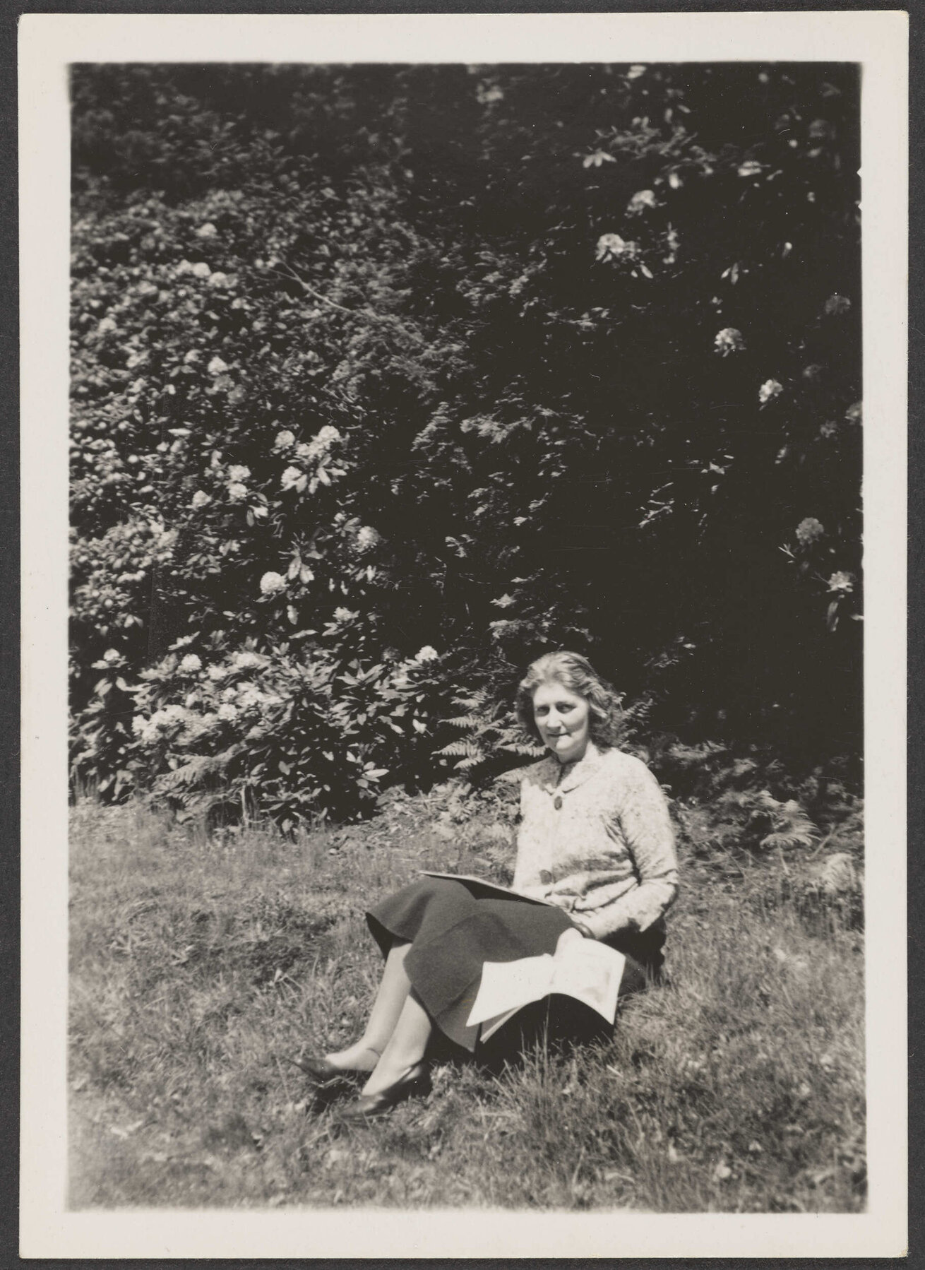 Woman on grassy bank with book [Mrs Lister-Kaye]