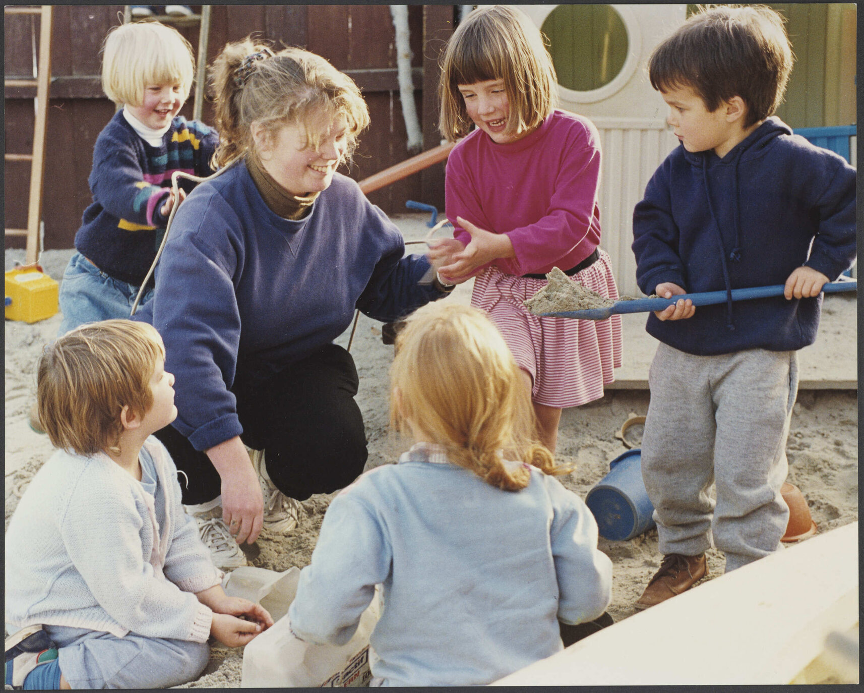 Teacher and children in sandpit