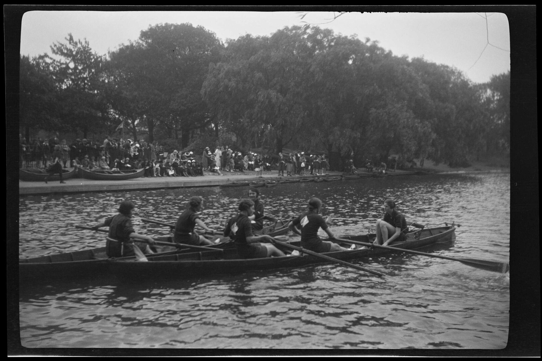 Young women rowing with crowd and trees in background [Girl Guides?]