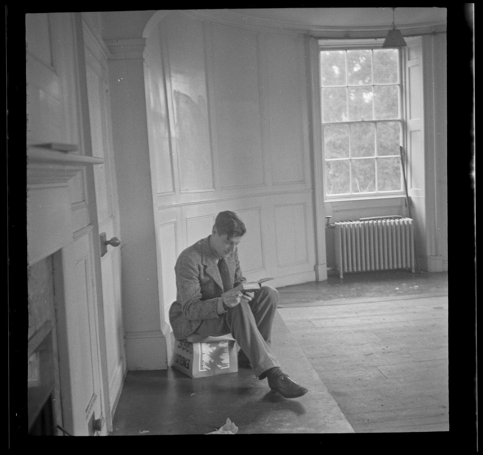 Man reading a book in an unfurnished room [Roger Cox]