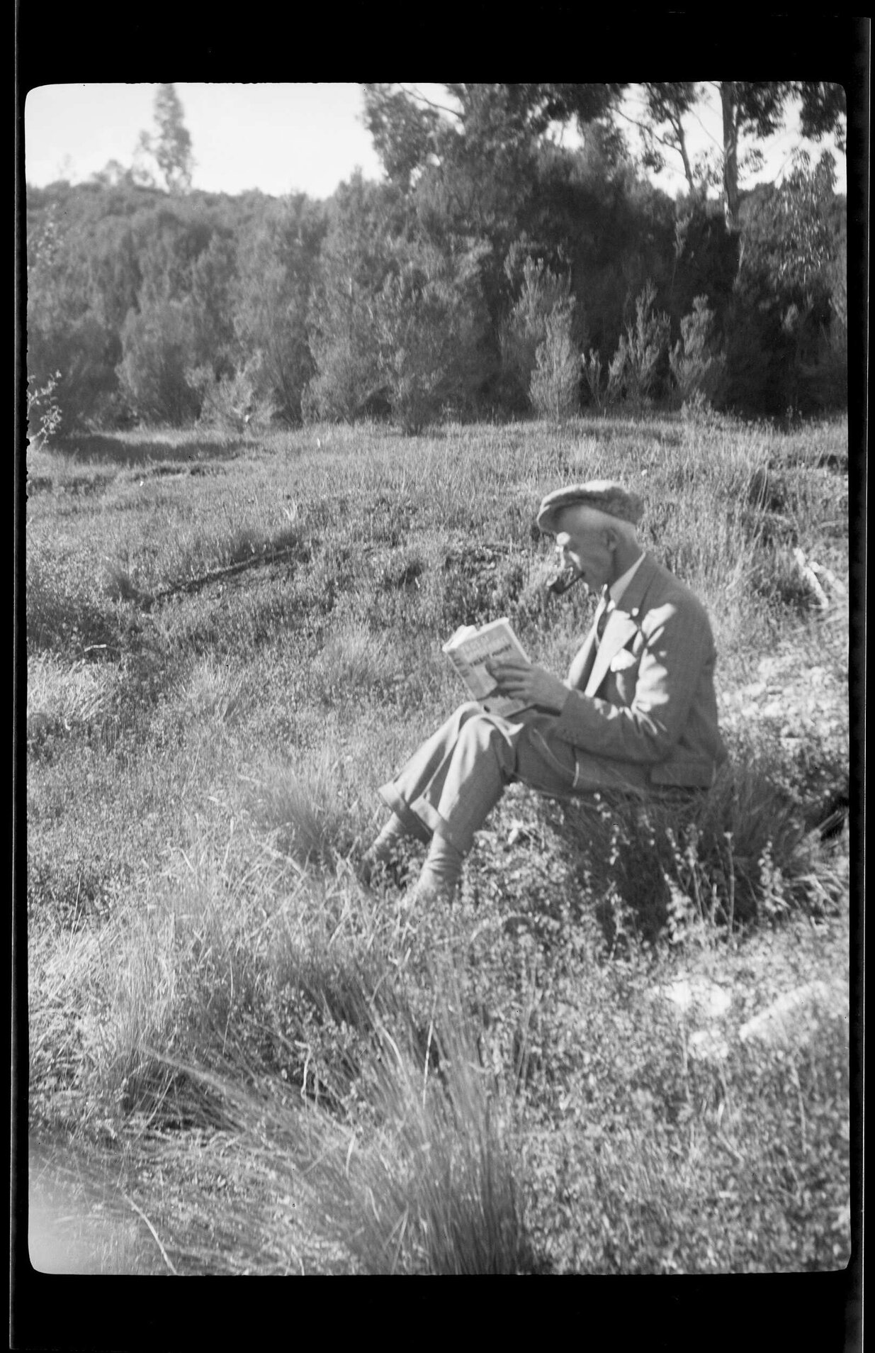 [Henry Brasch] reading a book outdoors