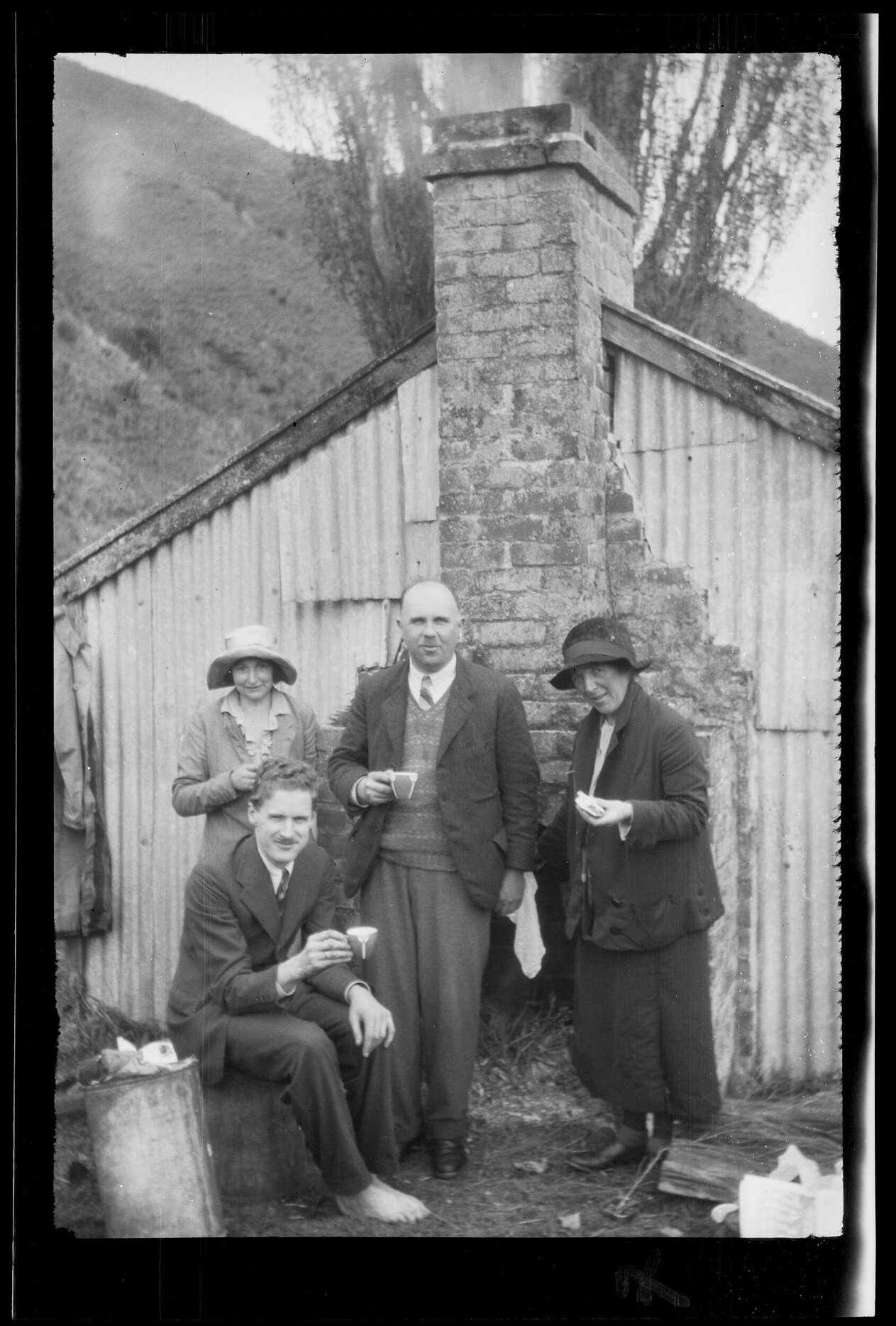 Victor Galway (centre) and three others in front of a hut