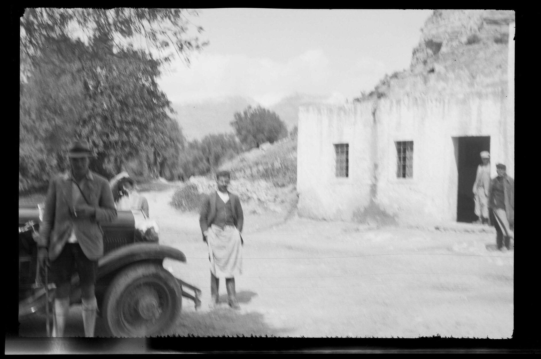 Five people next to a car and building