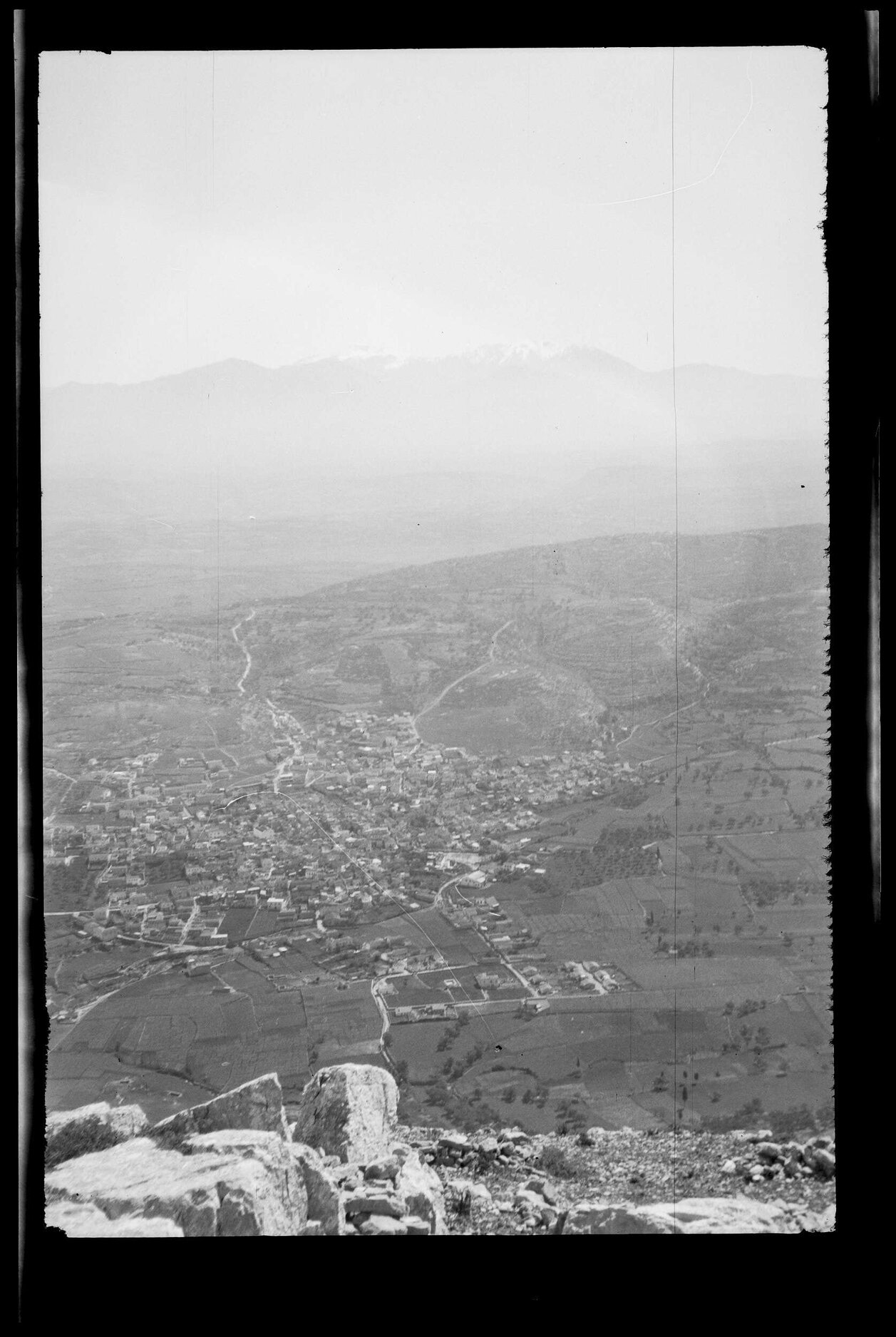Elevated view over town and countryside, with mountains in background