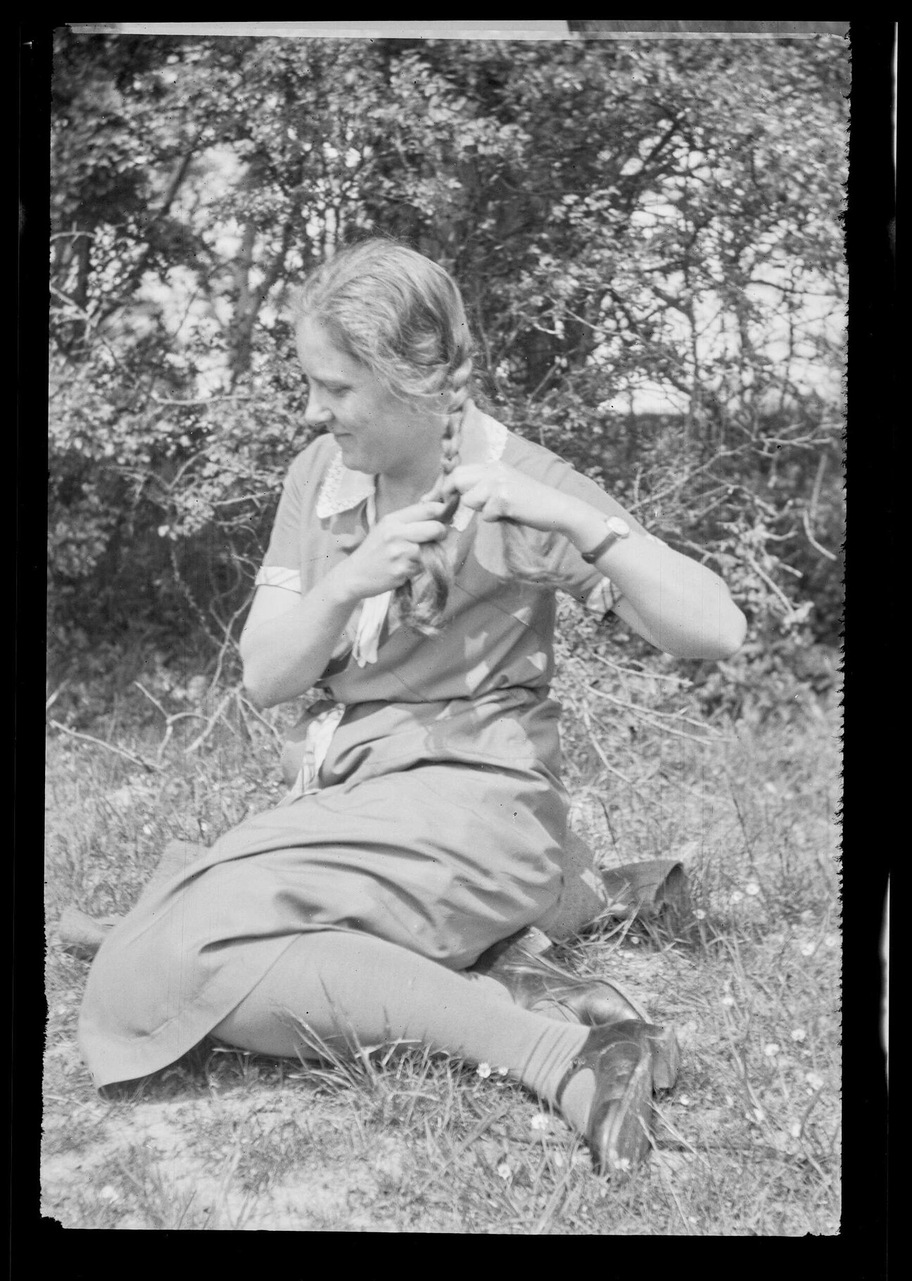Unidentified woman plaiting her hair