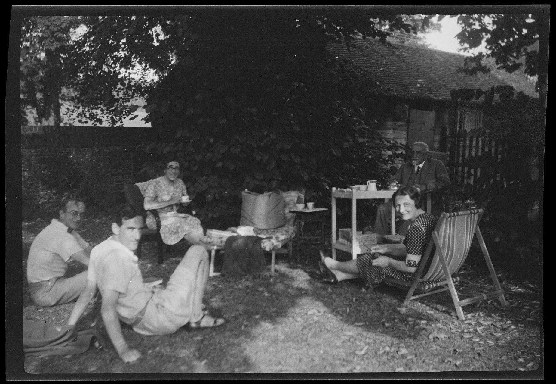 Group of five in garden, including Charles Brasch, Dora de Beer, and Willi Fels