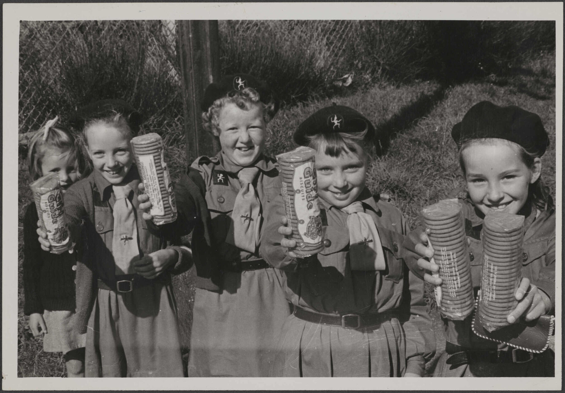 Brownies holding packets of Girl Guide Biscuits