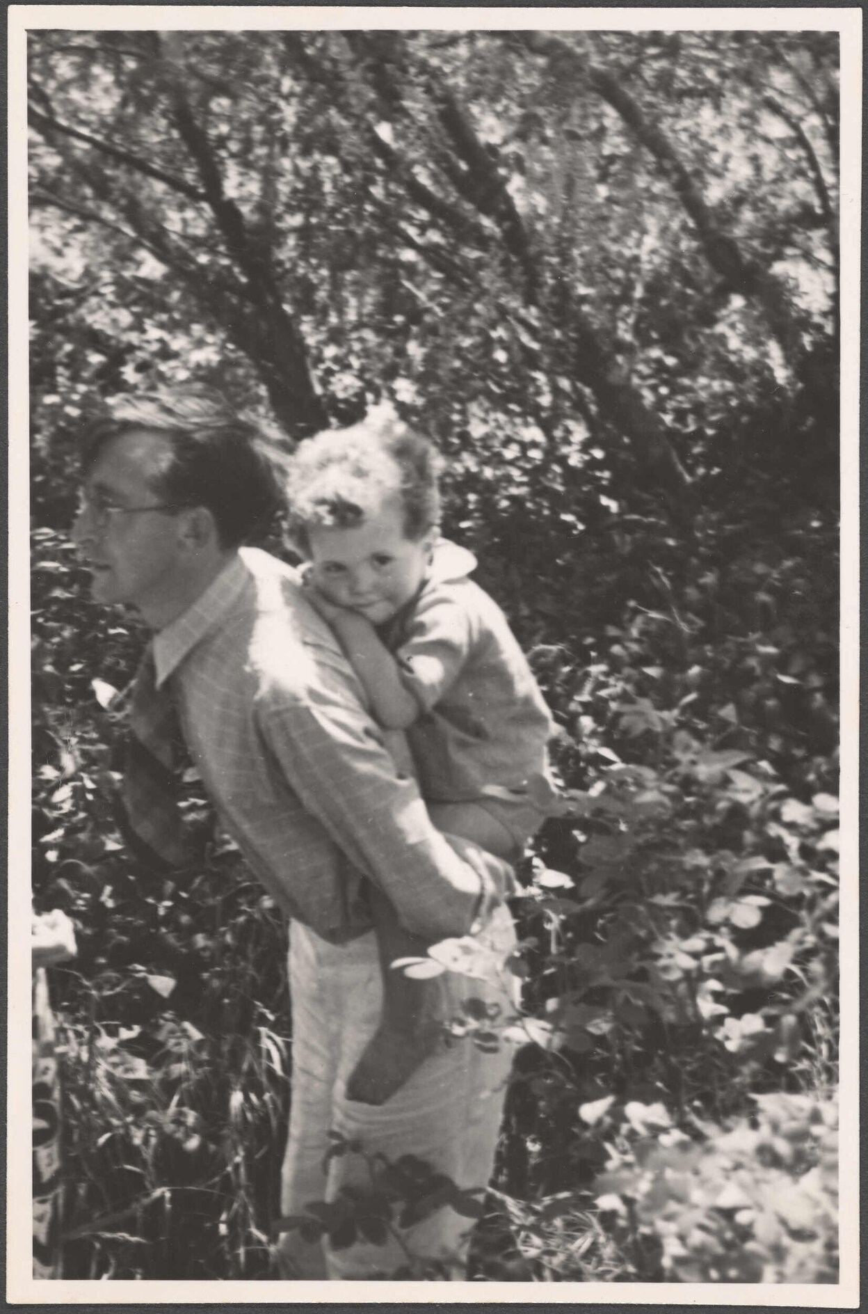 Unidentified man [Jack Bennett?] with child on piggyback