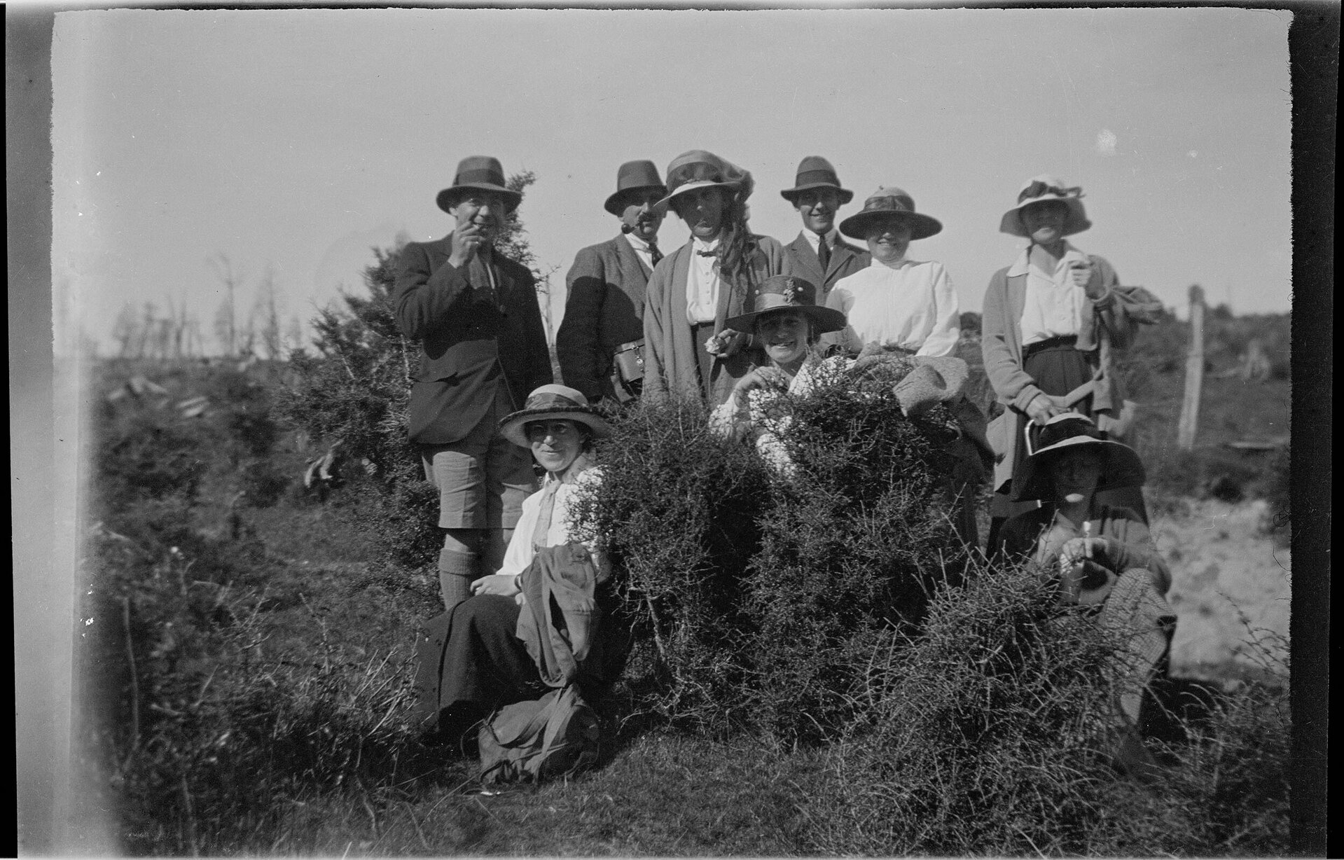 Nine people among shrubs on an outdoor trip