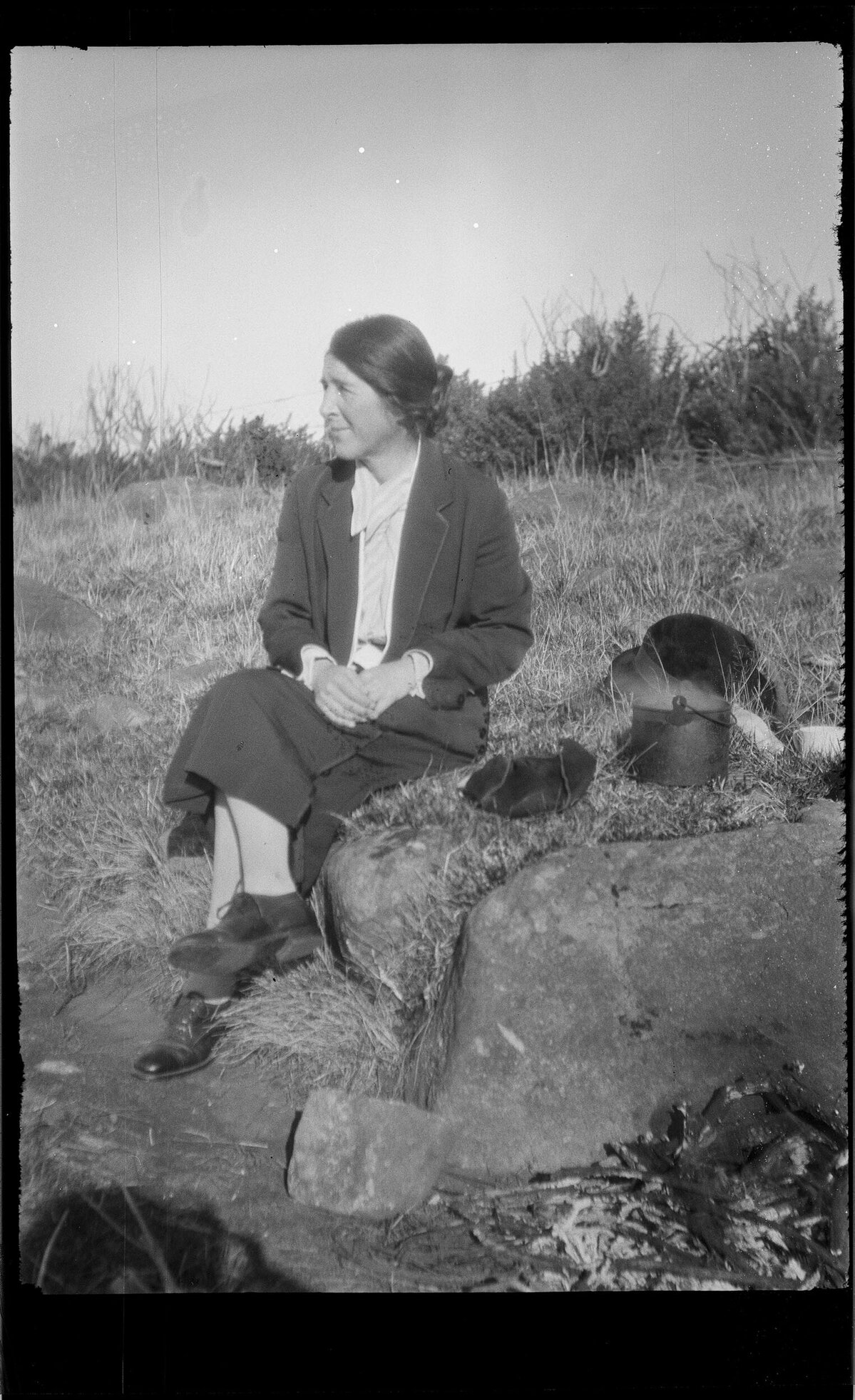 Woman sitting next to a steaming billy
