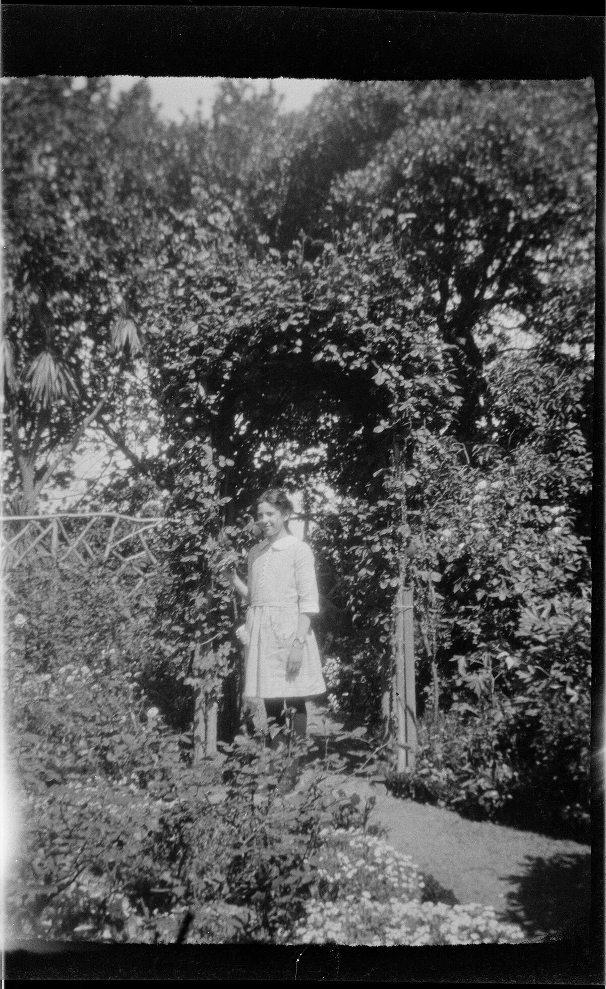 Girl standing beneath a garden arch
