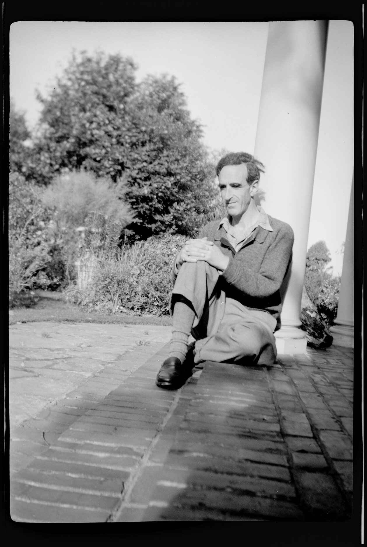 Charles Brasch sitting on step