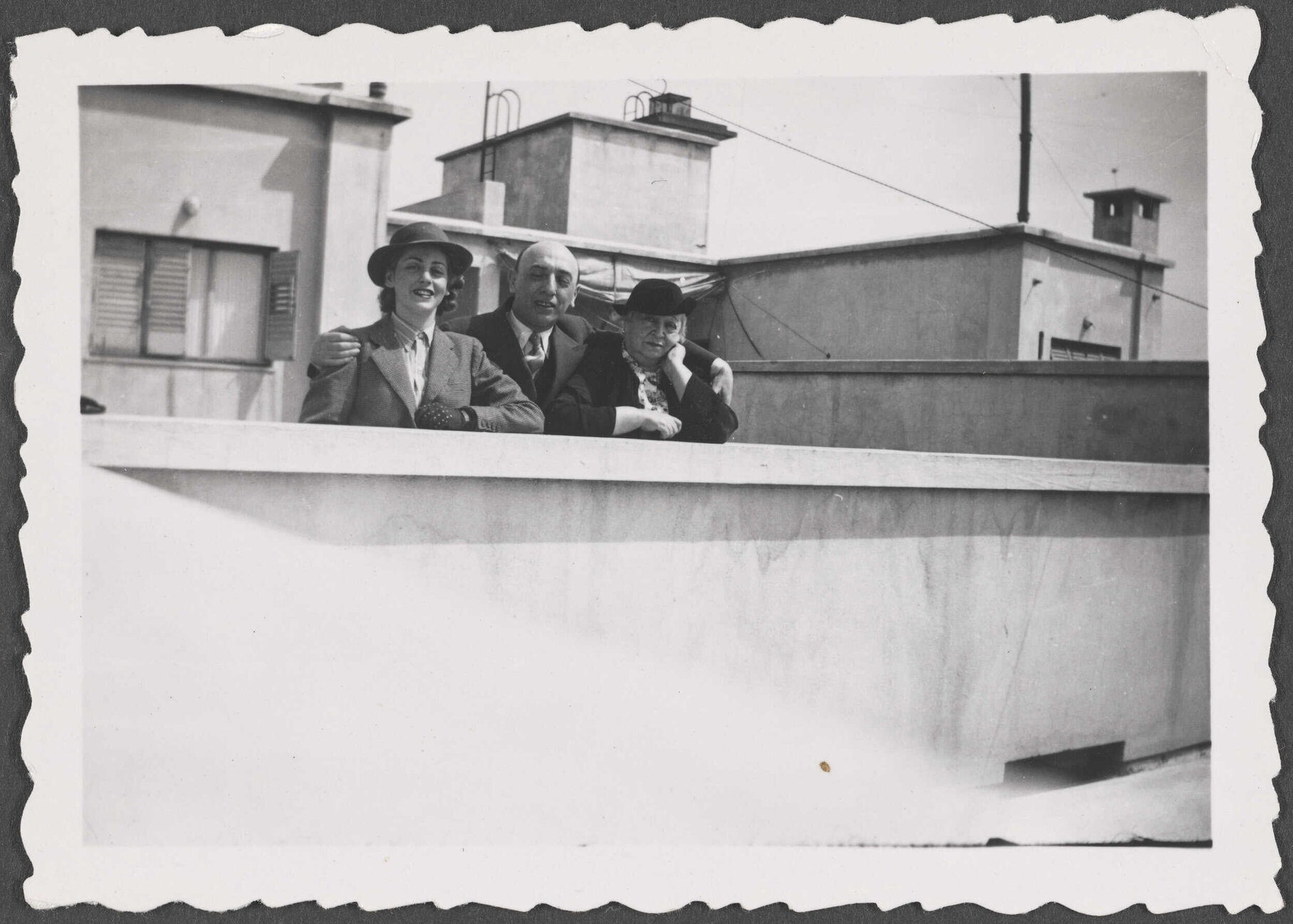 Unknown man and two women on a rooftop