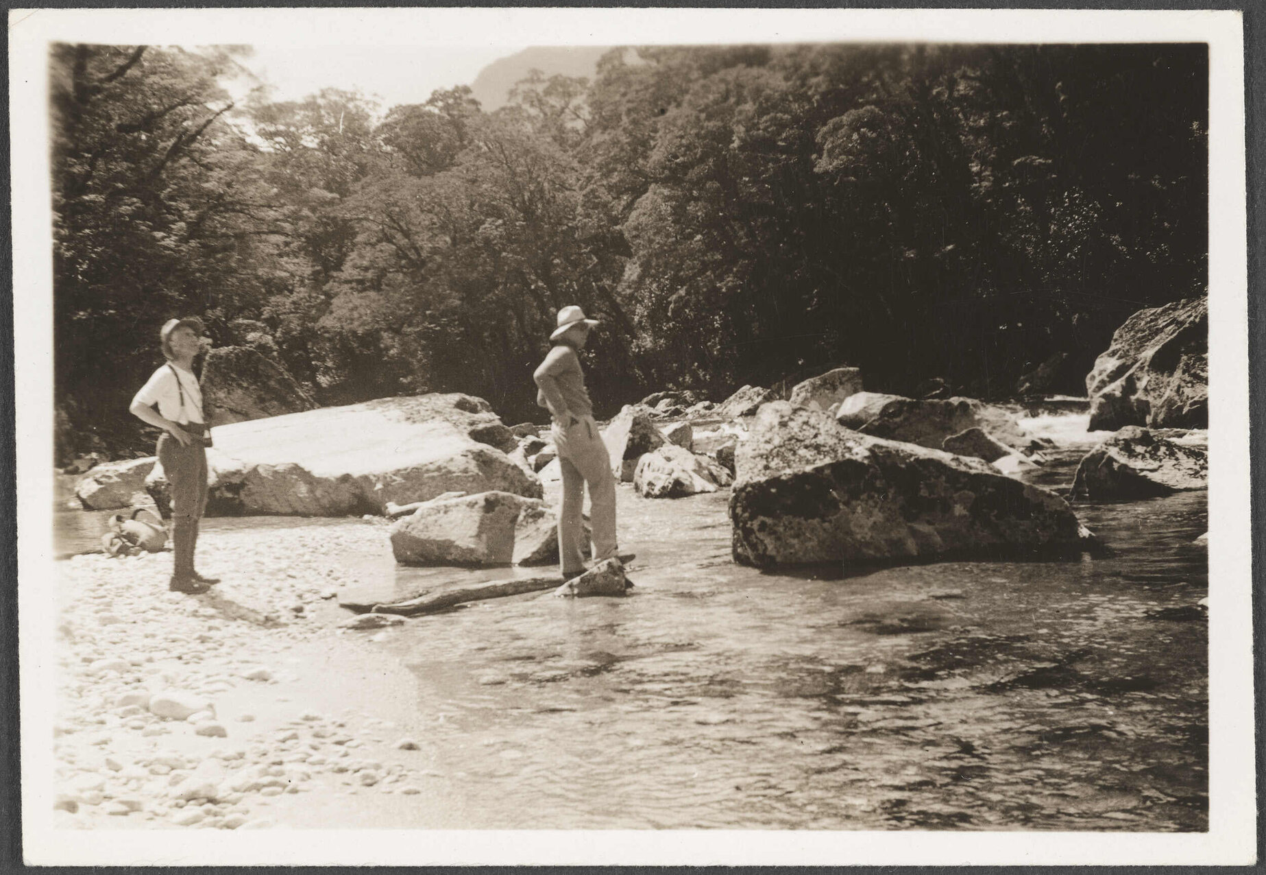 Two men crossing a river