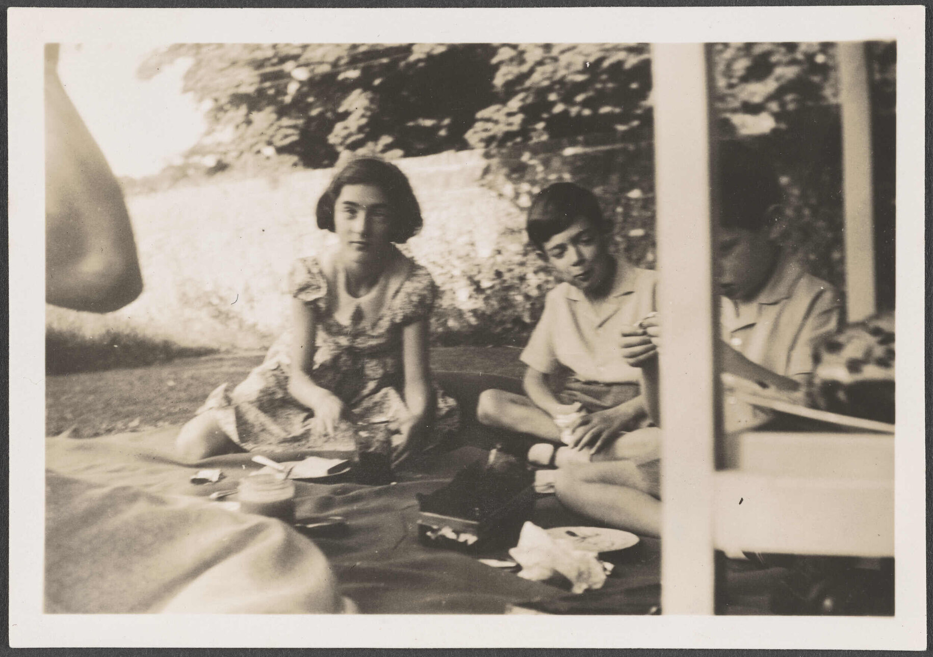 Three children on a blanket outside